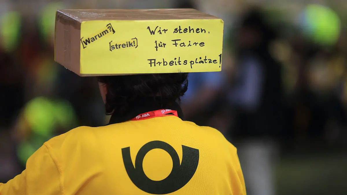 ARCHIV - 26.06.2015, Sachsen-Anhalt, Magdeburg: Eine Mitarbeiterin der Deutschen Post AG nimmt an einer Kundgebung der Gewerkschaft Verdi teil. Mitarbeiterinnen und Mitarbeiter der Post wollen auch am Freitag auf ihre Forderung nach mehr Lohn aufmerksam machen. Foto: Jens Wolf/dpa-Zentralbild/dpa +++ dpa-Bildfunk +++