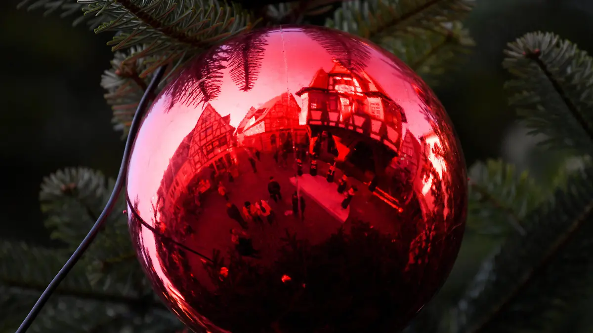 Das historische Rathaus spiegelt sich am 07.12.2017 am Marktplatz von Michelstadt (Hessen) in der roten Kugel des großen Weihnachtsbaumes. Der Weihnachtsmarkt der Odenwaldstadt ist alljährlich Anziehungspunkt für viele Touristen. Foto: Arne Dedert/dpa +++(c) dpa - Bildfunk+++