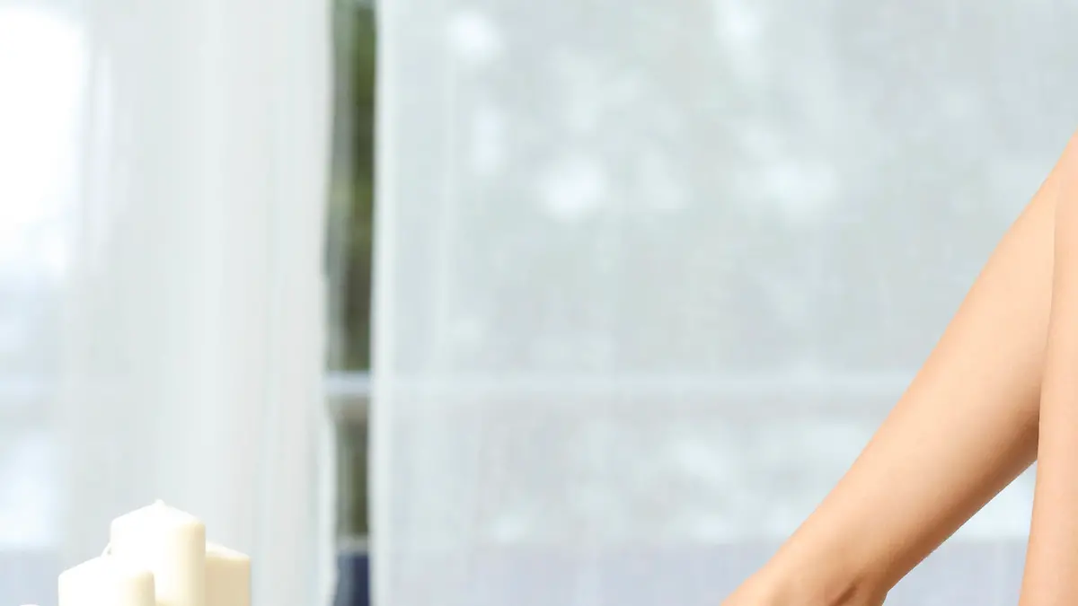 Profile of a perfect woman legs sitting on a couch at home hair removal concept