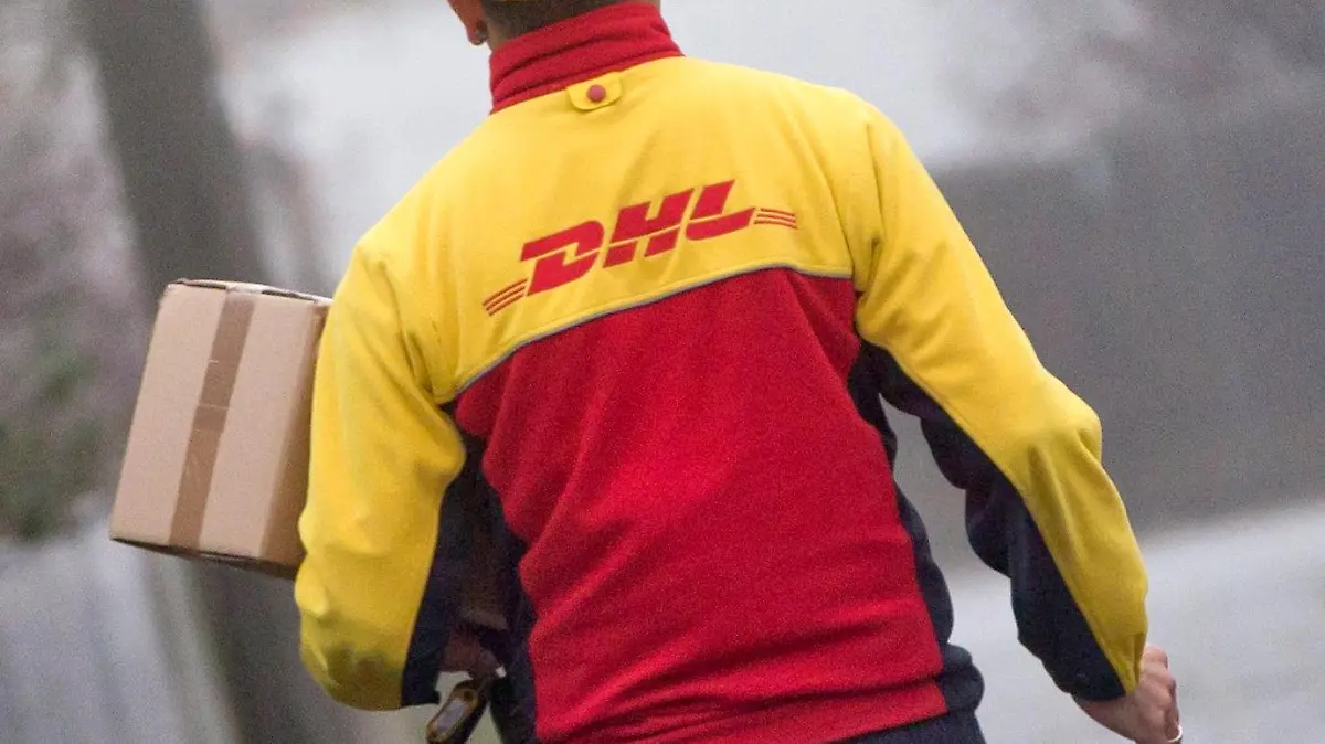 ARCHIV - ILLUSTRATION - Ein DHL-Paketzusteller liefert am 09.12.2014 in seinem Zustellbezirk Sendungen aus. (zu dpa "Unbekannte erpressen DHL im Weihnachtsgeschäft - Millionen-Forderung" vom 03.12.2017) Foto: Daniel Karmann/dpa +++(c) dpa - Bildfunk+++