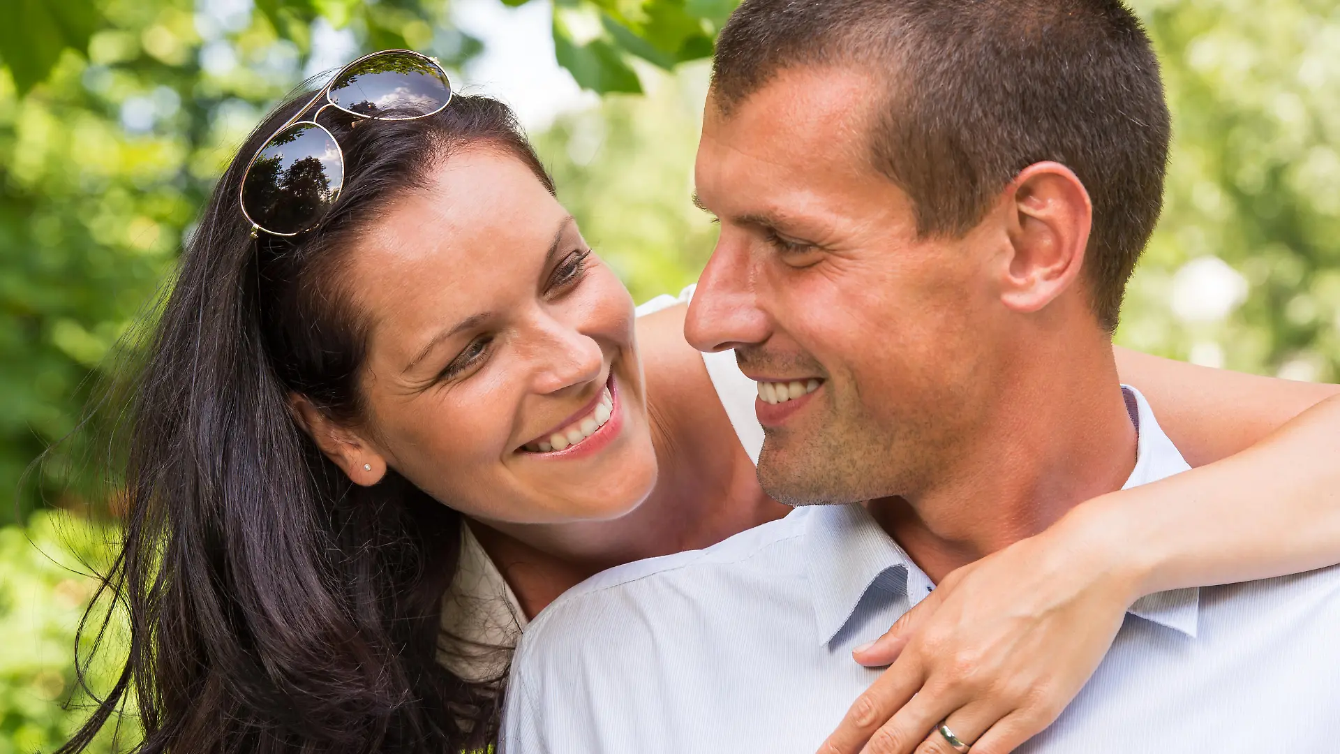 Portrait of happy affectionate couple hugging in park