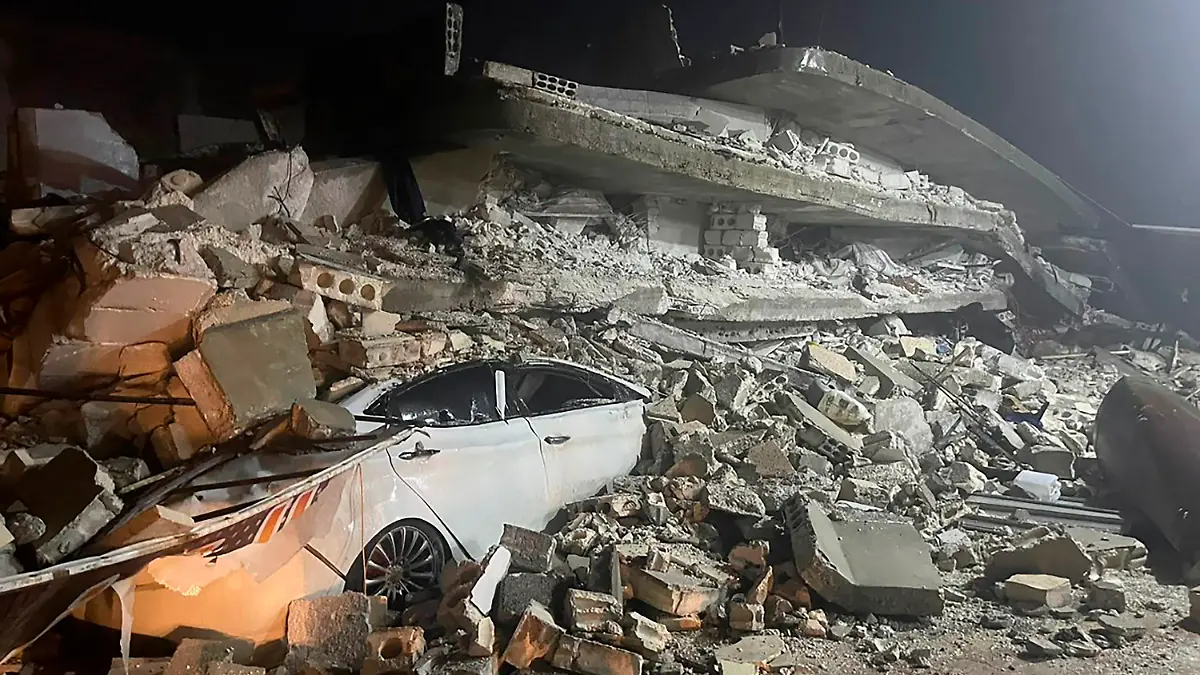 06.02.2023, Syrien, Azmarin: Ein Auto ist unter den Trümmern eines eingestürzten Gebäudes in der Stadt Azmarin in der nordsyrischen Provinz Idlib zu sehen. Zwei heftige Erdbeben haben kurz nacheinander am frühen Montagmorgen den Südosten der Türkei erschüttert. Das Epizentrum lag nach Angaben des Geoforschungszentrums Potsdam in beiden Fällen nahe der Stadt Gaziantep unweit der Grenze zu Syrien. Demnach ereigneten sich die Beben gegen 4.17 Uhr (Ortszeit/2.17 Uhr MEZ) und 4.28 Uhr (Ortszeit/2.28 Uhr MEZ) in einer Tiefe von 10 Kilometern. Foto: Ghaith Alsayed/AP/dpa +++ dpa-Bildfunk +++