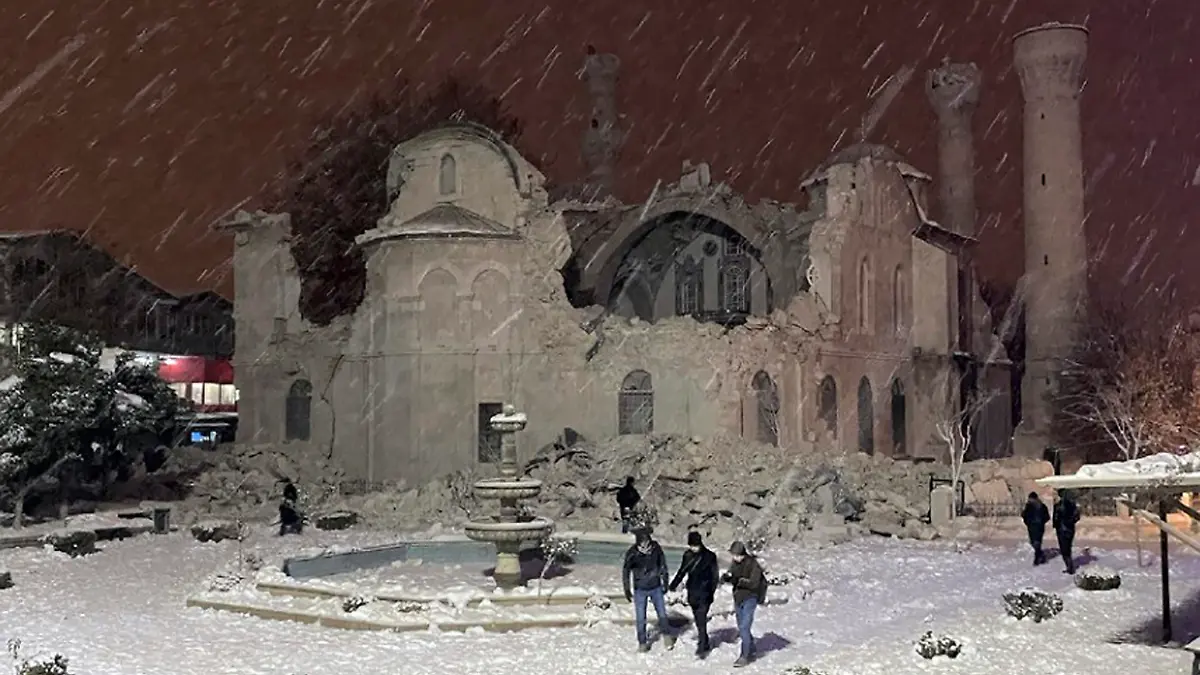 06.02.2023, Türkei, Malatya: Menschen gehen neben einer durch ein Erdbeben zerstörten Moschee. Ein starkes Erdbeben hat im Südosten der Türkei und in Syrien mehrere Gebäude zum Einsturz gebracht, und es werden viele Opfer befürchtet. Foto: Uncredited/DIA Images/AP/dpa +++ dpa-Bildfunk +++