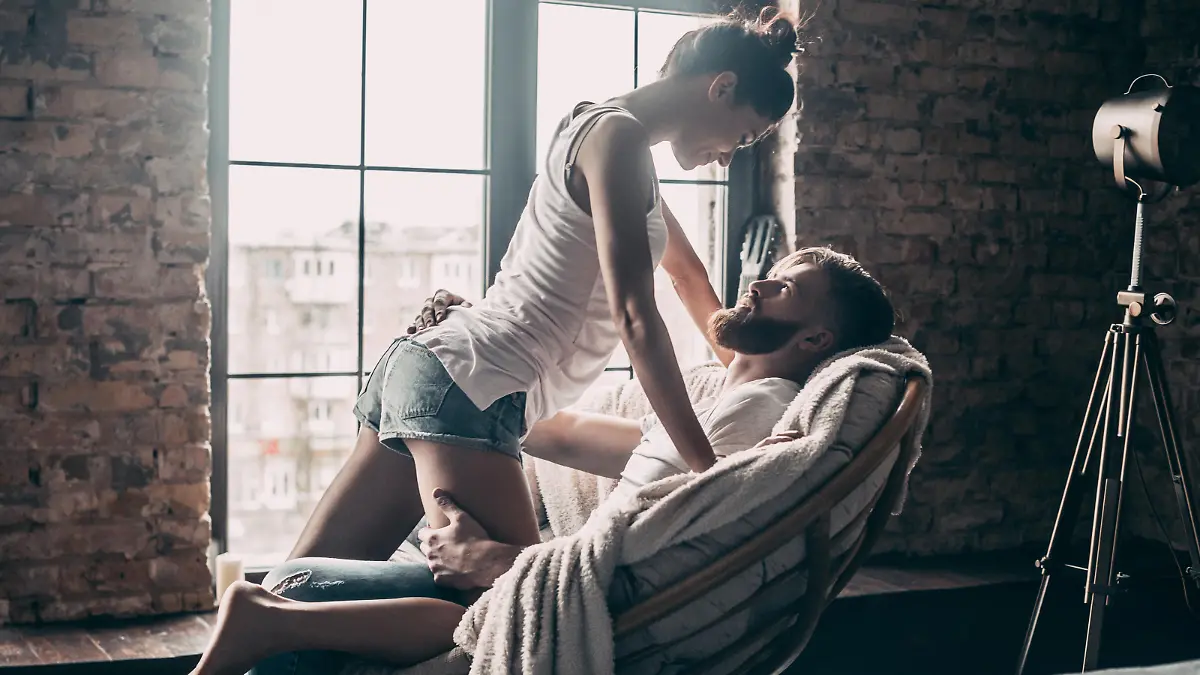 Young passionate couple looking on each other while spending free time at home