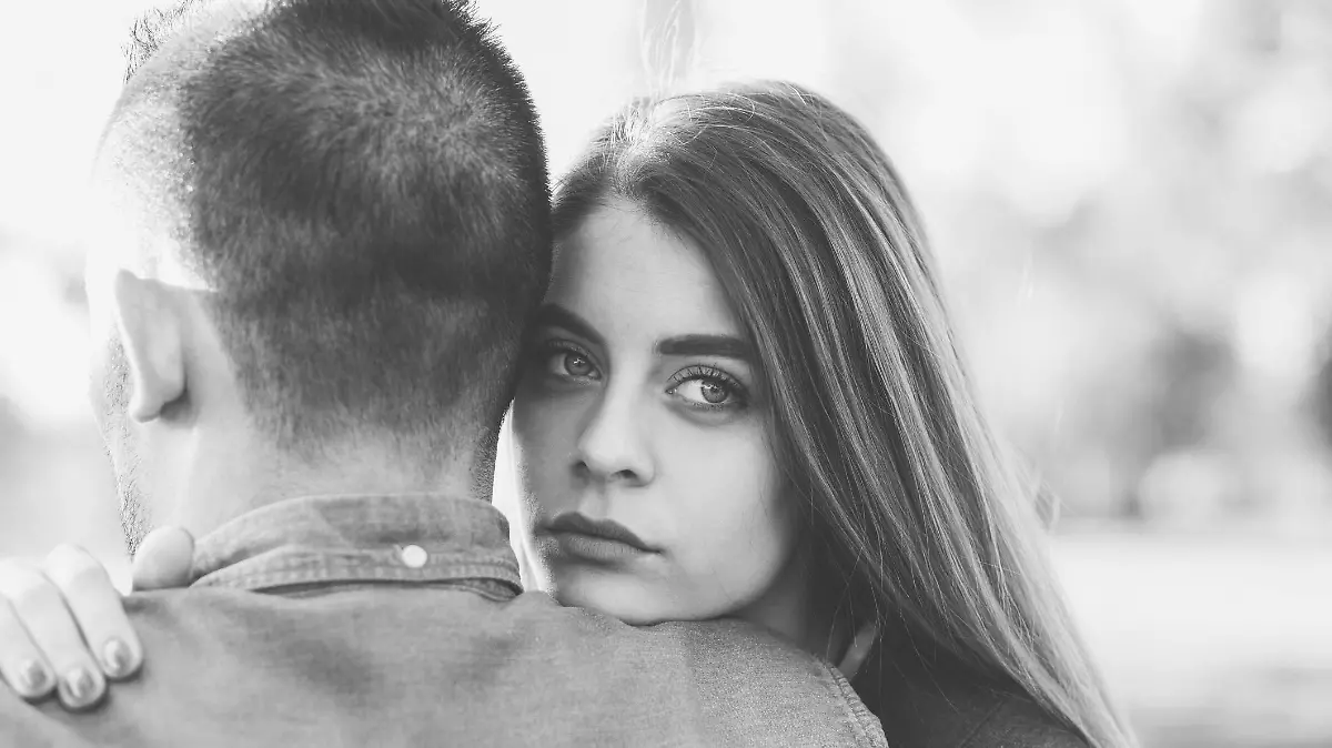 Unhappy woman hugging her boyfriend