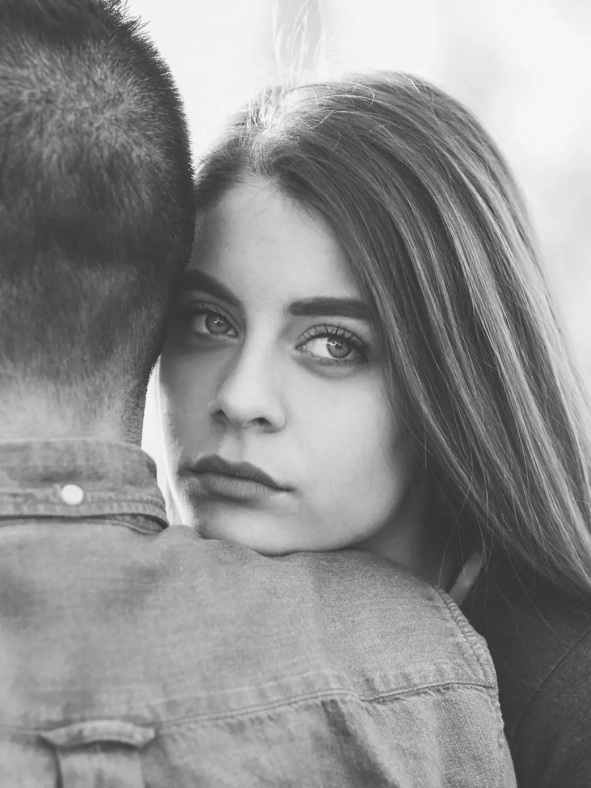 Unhappy woman hugging her boyfriend