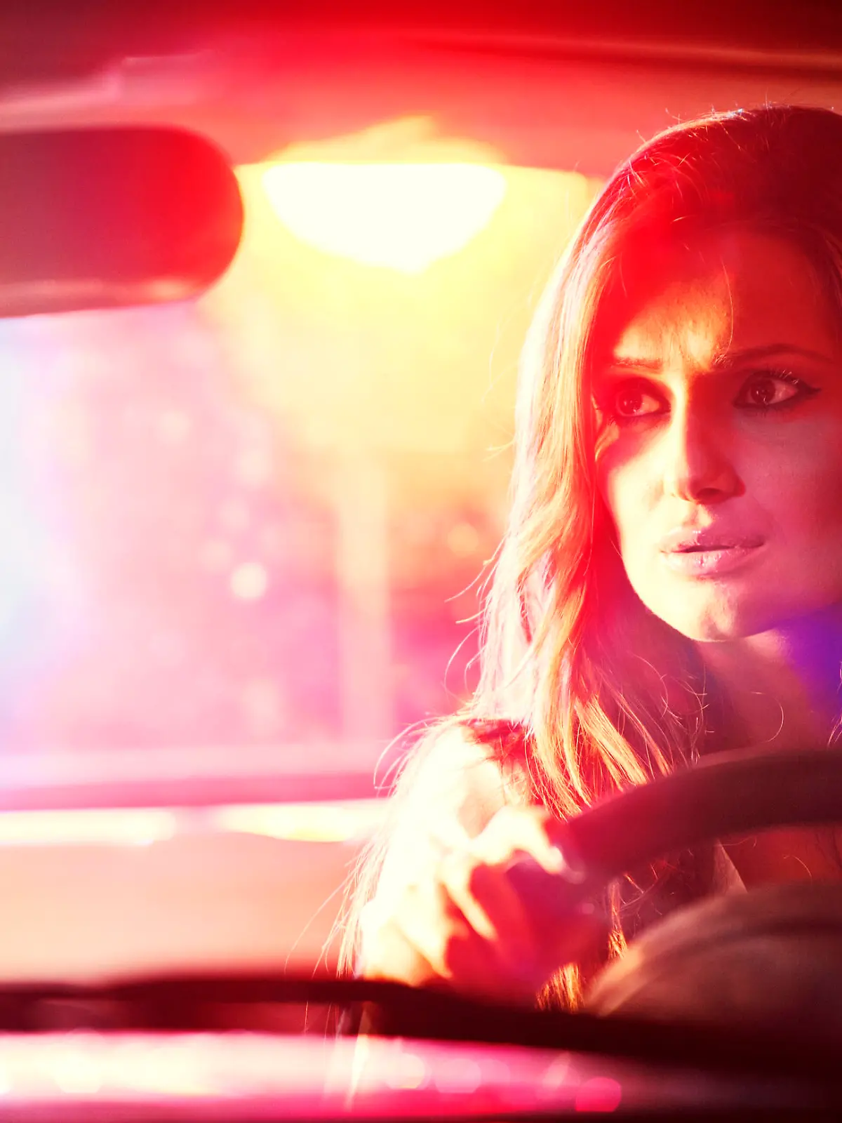Frau fährt Auto bei Nacht und hat Sehprobleme.