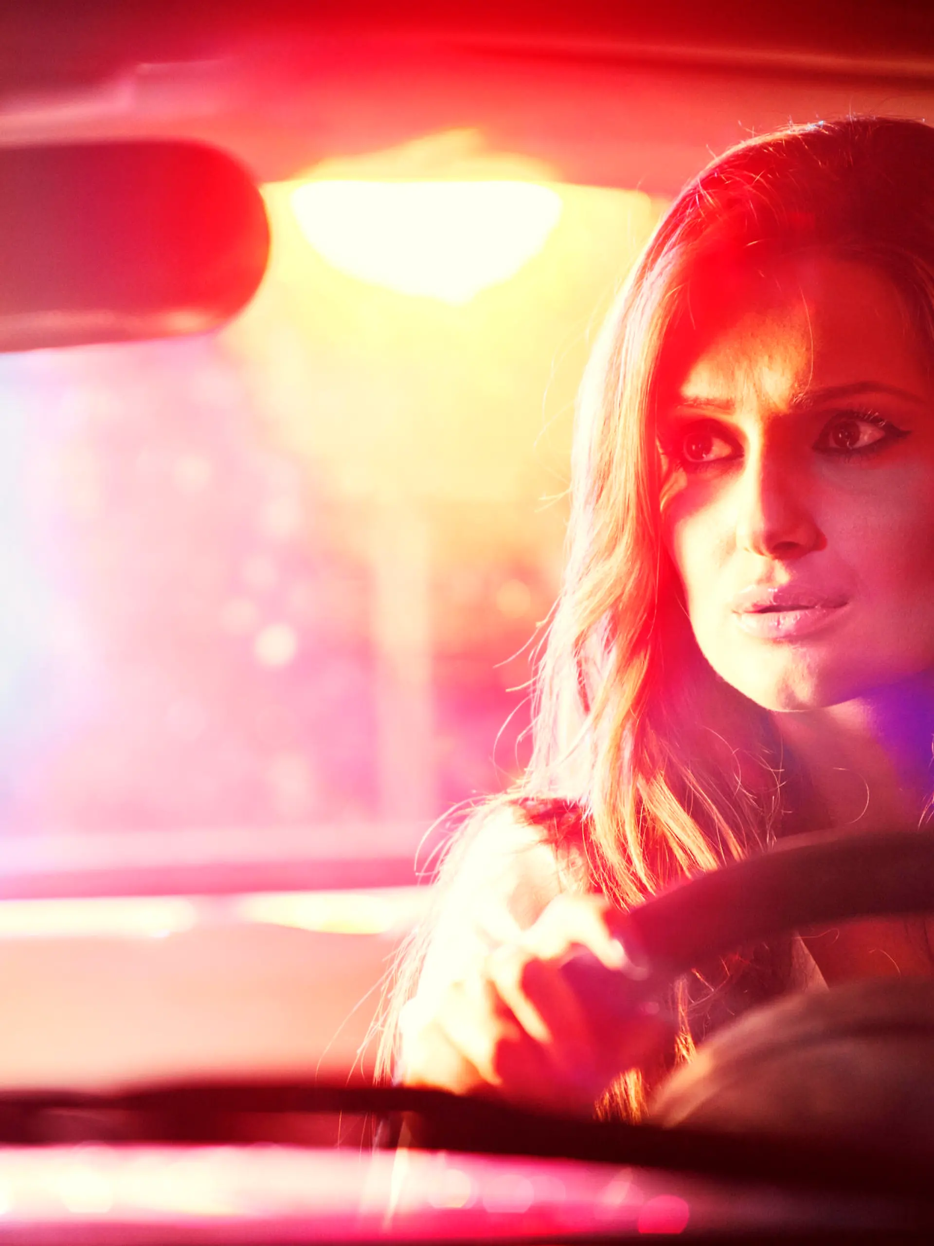 Frau fährt Auto bei Nacht und hat Sehprobleme.