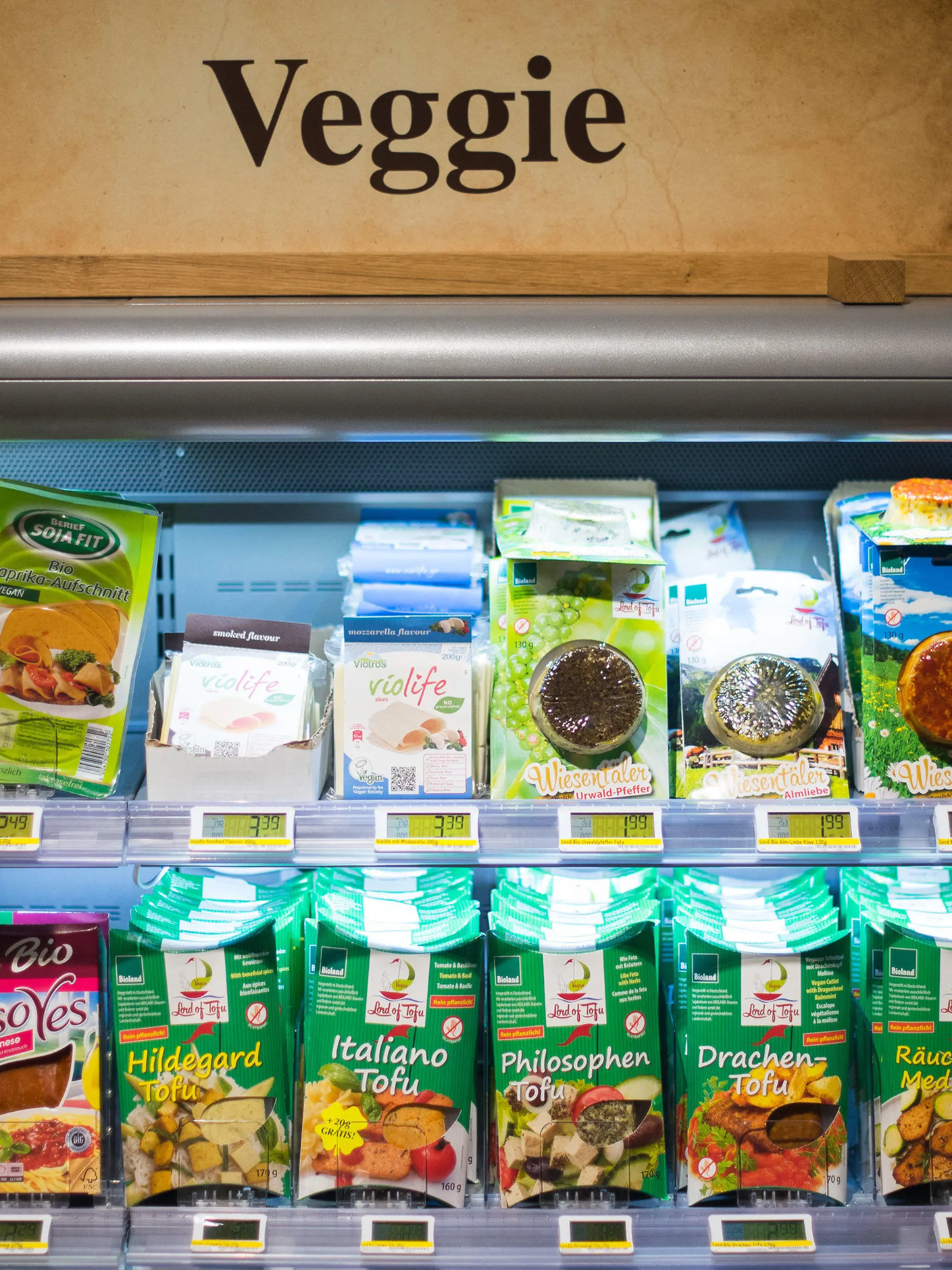 ARCHIV - Ein Schild «Veggie» steht am 11.05.2015 in Hamburg in einem Edeka-Markt auf einem Kühlregal mit vegetarischen Produkten. Vegetarische oder vegane Ernährungsweise liegt im Trend. Selbst bekannte Wursthersteller stocken ihr Produktportfolio mit Fleischersatz auf. Foto: Daniel Bockwoldt/dpa (zu lni "«Nur ein Revolutiönchen» - Fleischkonsum trotz Veggie-Trend konstant" vom 11.06.2015) +++(c) dpa - Bildfunk+++