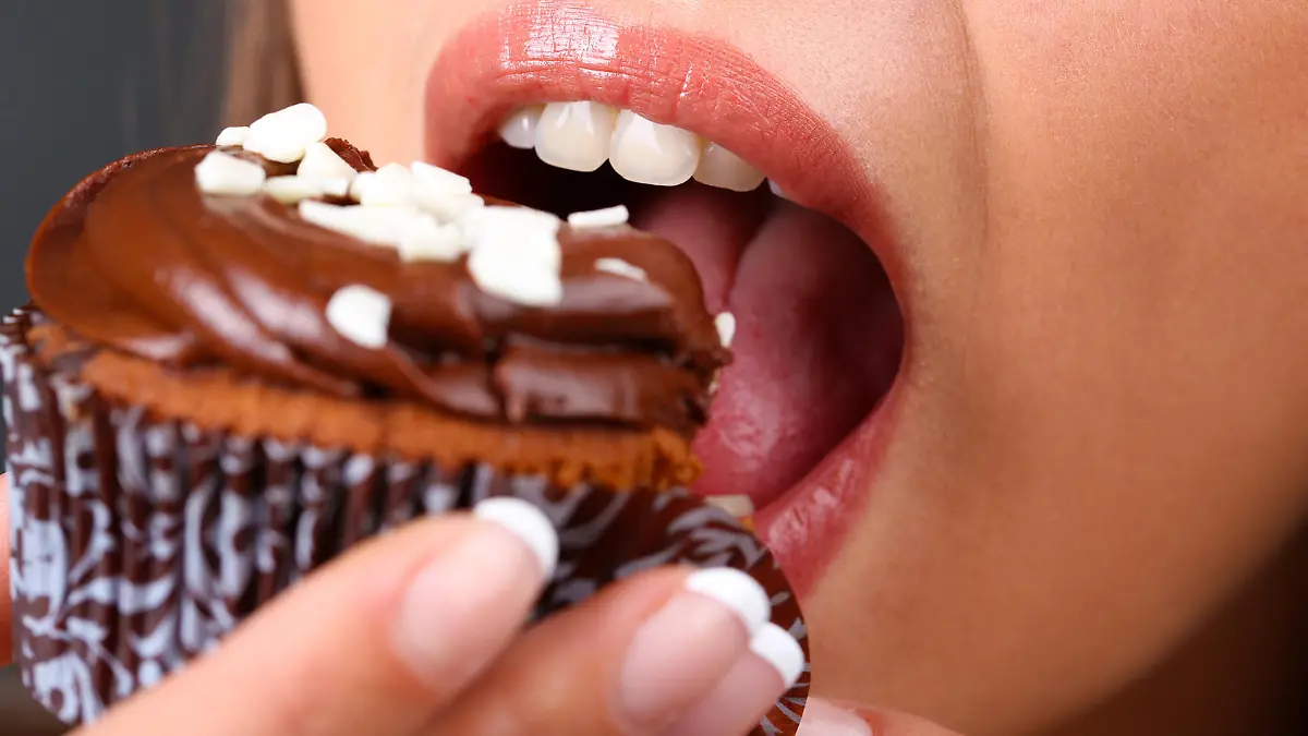 Closeup of woman eating chocolate cupcake