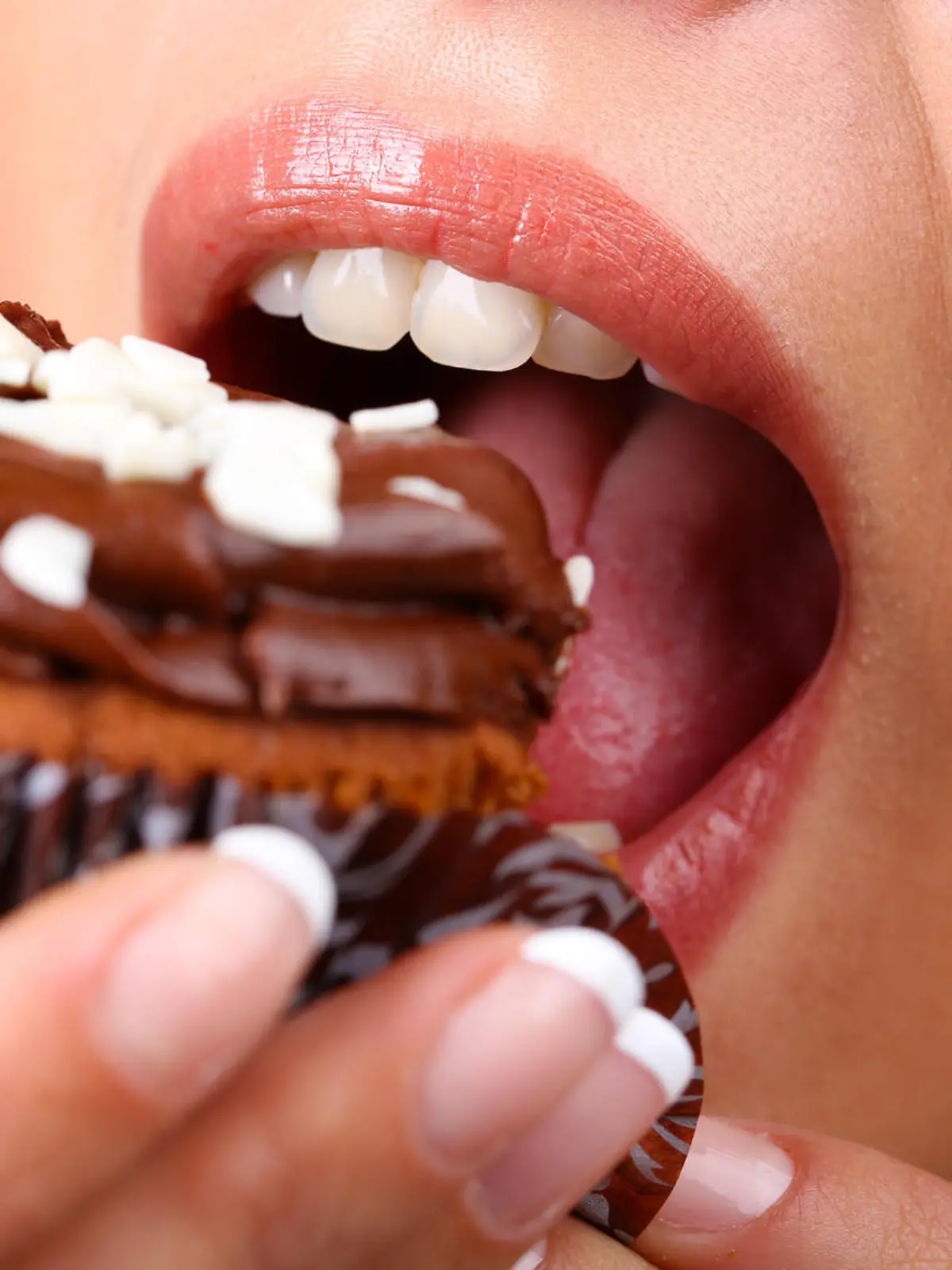Closeup of woman eating chocolate cupcake