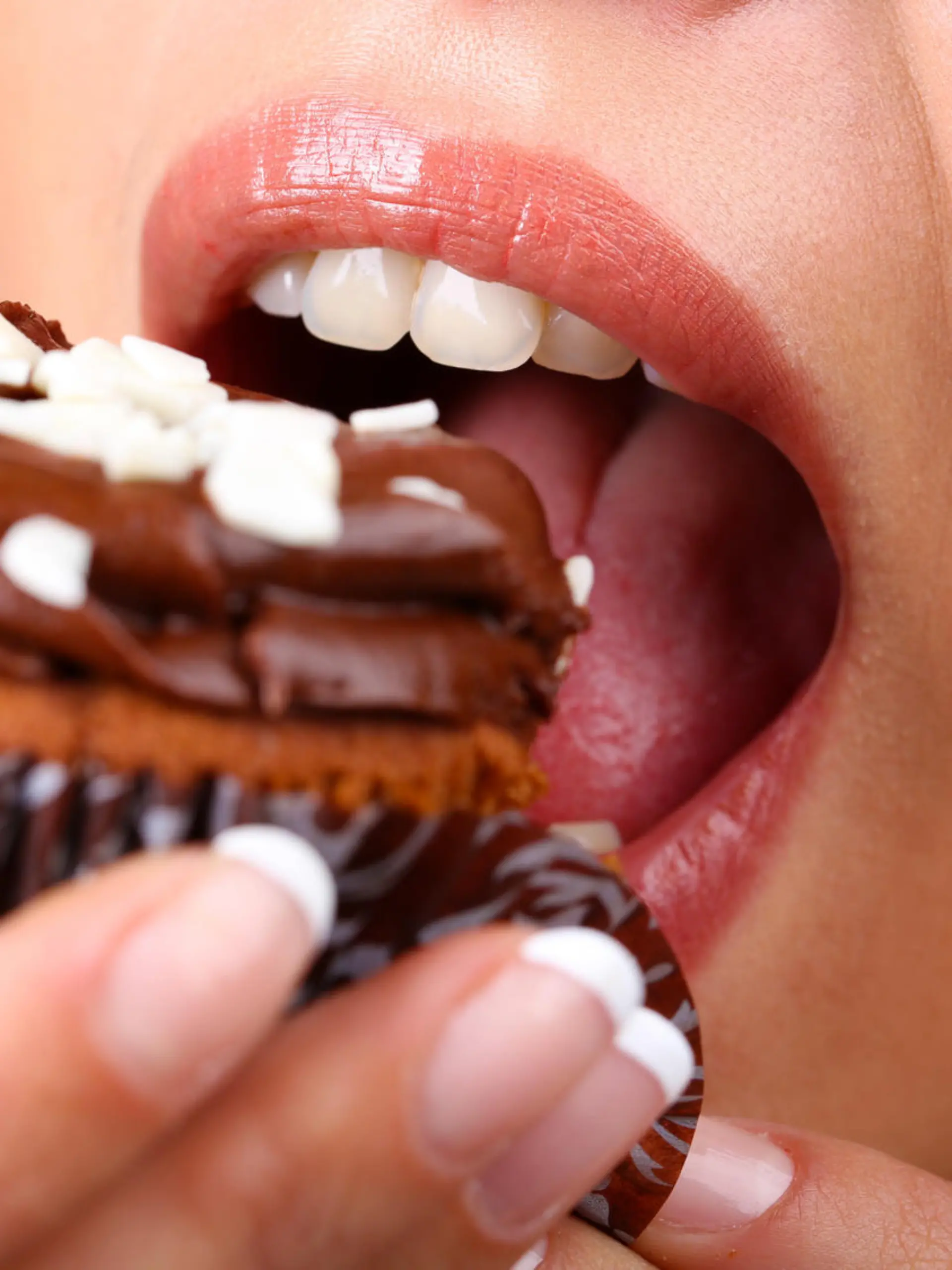 Closeup of woman eating chocolate cupcake