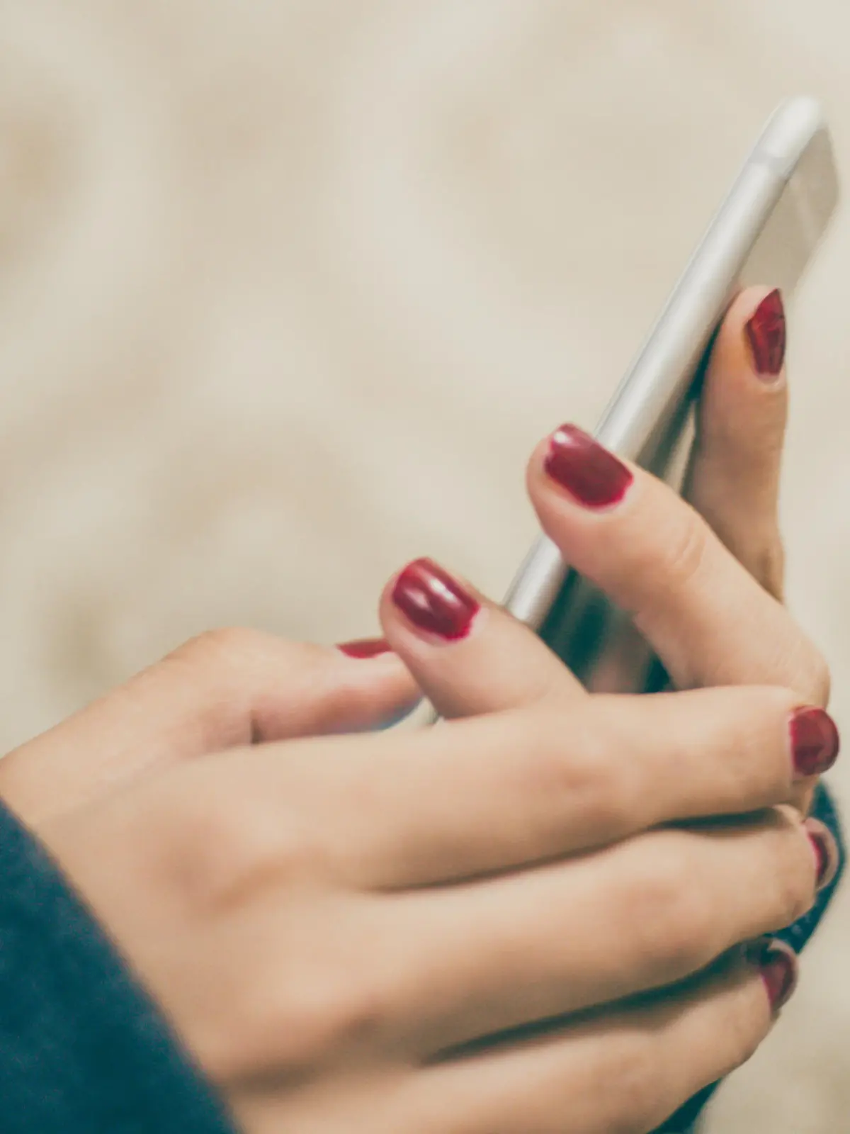 Woman hands holding smart phone on vintage background, close-up