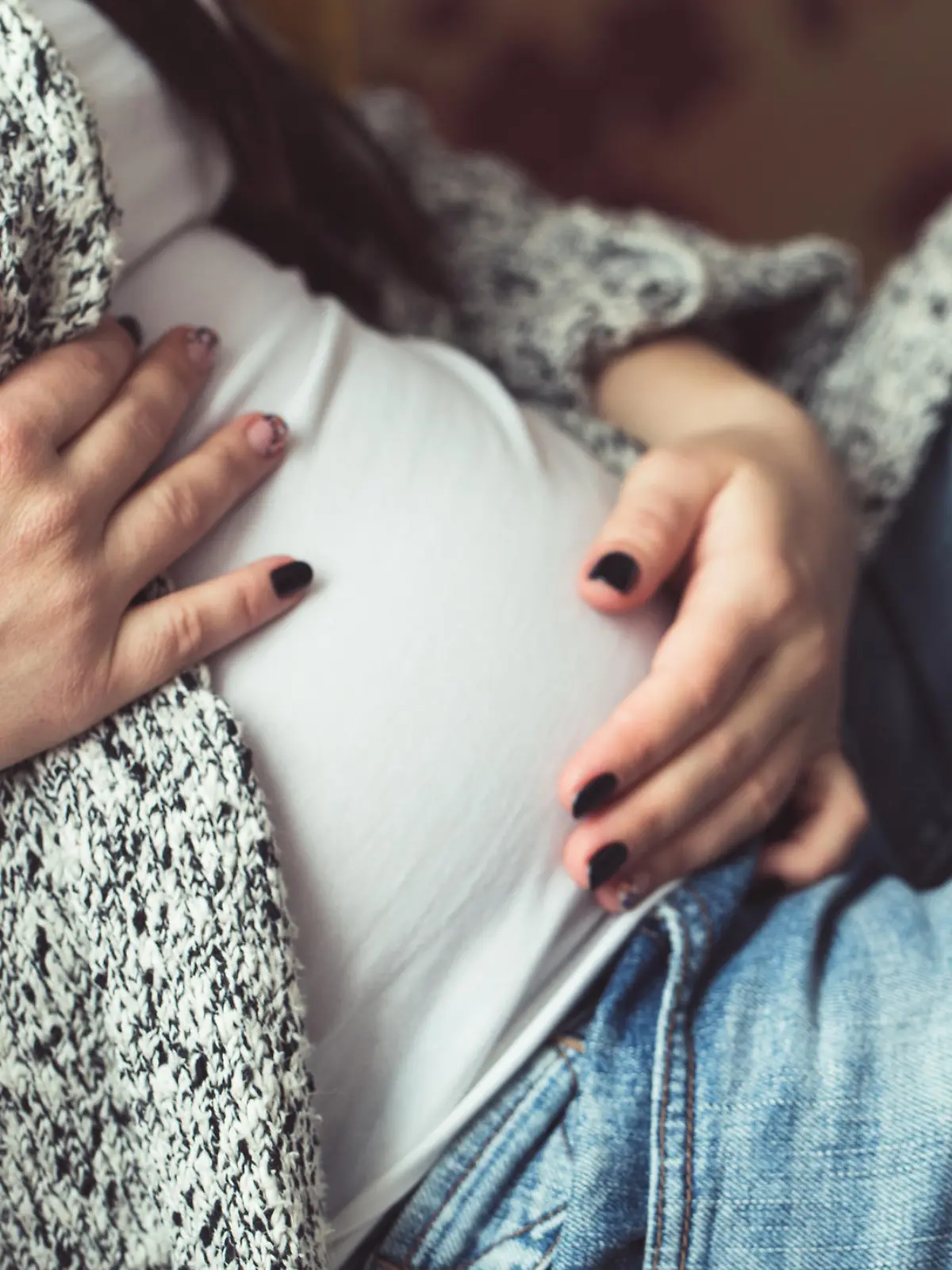 Young pregnant woman sitting on sofa close up
