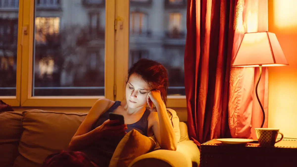 Unhappy woman at home text messaging