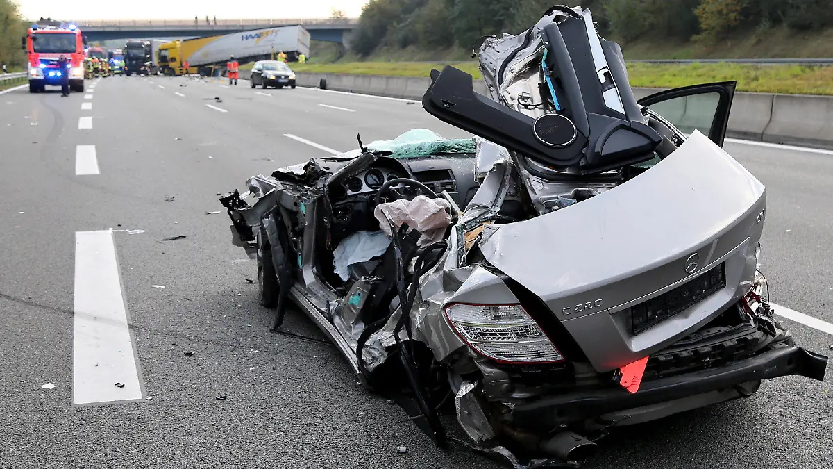 Ein verunglückter Pkw, der zuvor gegen den Lkw im Hintergrund geprallt war, steht am 19.10.2017 auf der Autobahn A3 bei Aschaffenburg (Bayern). Der Fahrer des Lastwagens hatte die Kontrolle über seinen Transporter verloren, die Betonbegrenzung zwischen den Fahrbahnen durchbrochen und war in den Gegenverkehr gefahren. Für den Fahrer des entgegenkommenden Wagens kam jede Hilfe zu spät. (zu dpa "Autofahrer stirbt bei Frontalkollision mit Lkw auf Autobahn" vom 19.10.2017) Foto: Ralf Hettler/dpa +++(c) dpa - Bildfunk+++