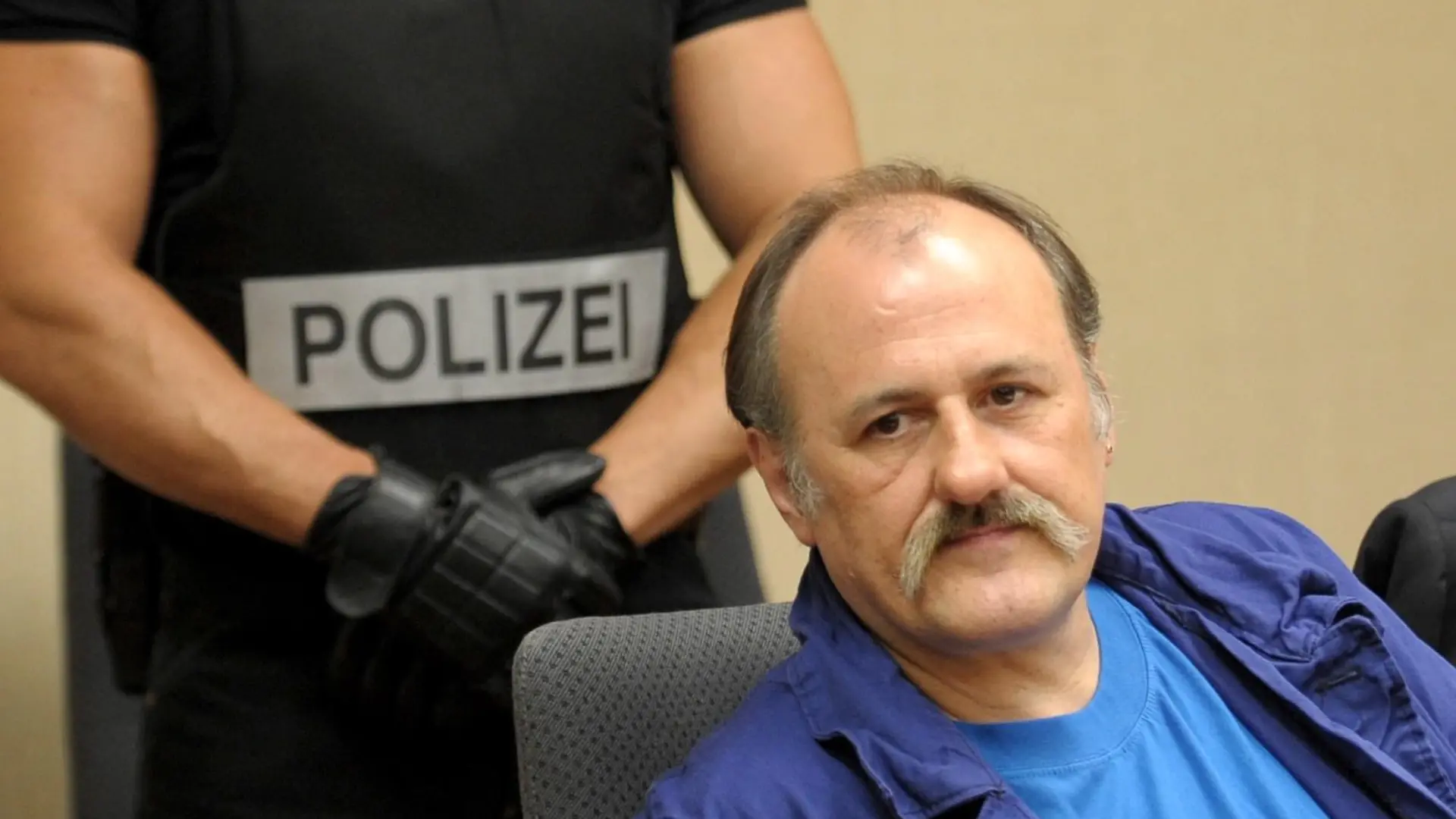 Der Gladbecker Geiselgangster Hans-Jürgen Rösner (r) sitzt am Dienstag (11.08.2009) im Amtsgericht in Bochum. Dahinter steht ein Beamter eines Spezialeinsatzkommandos. Rösner muss sich wegen Drogenhandels verantworten. Der 52-Jährige soll im Gefängnis dabei erwischt worden sein, wie er sieben Gramm Heroin portionierte. Rösner gilt als einer der bekanntesten Schwerverbrecher Deutschlands. Foto: Franz-Peter Tschauner dpa/lnw (zu lnw 7010 vom 11.08.2009) +++(c) dpa - Report+++