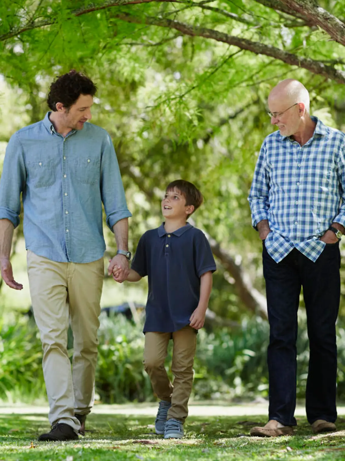 Full length of three generation males walking together in park