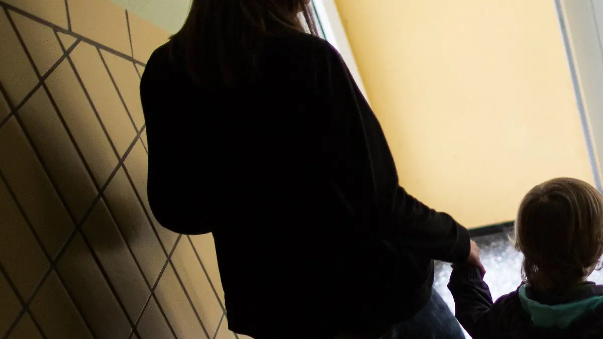 ARCHIV - Eine alleinerziehende Mutter geht am 01.07.2016 in Dortmund (Nordrhein-Westfalen) mit ihrem Sohn durch einen Hausflur die Treppe herunter. 1,6 Millionen Menschen im wohlhabenden Südwesten sind von Armut bedroht. (zu dpa «Armut im Reichtum - Alleinerziehende und Migranten mit hohem Risiko» vom 16.10.2017) Foto: Marcel Kusch/dpa +++(c) dpa - Bildfunk+++