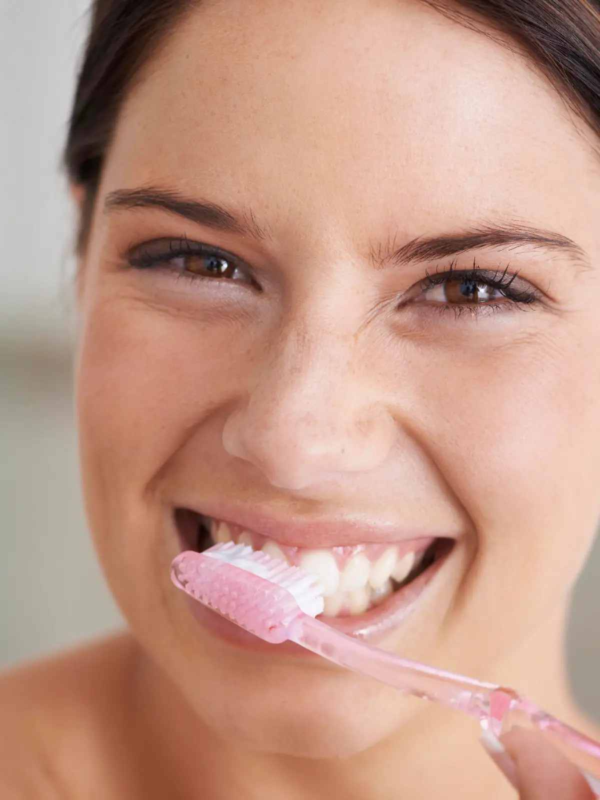 A gorgeous young brunette brushing her teeth in the morning