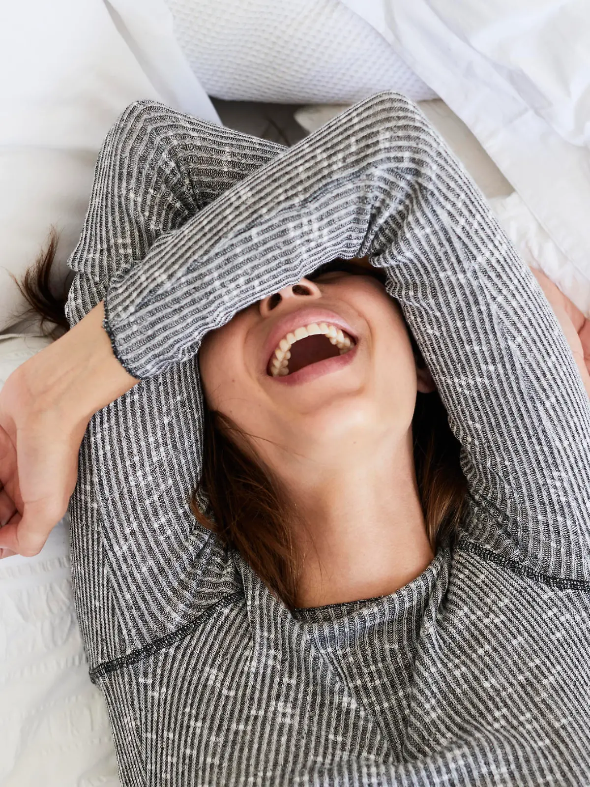 Laughing babe in bed, overhead view