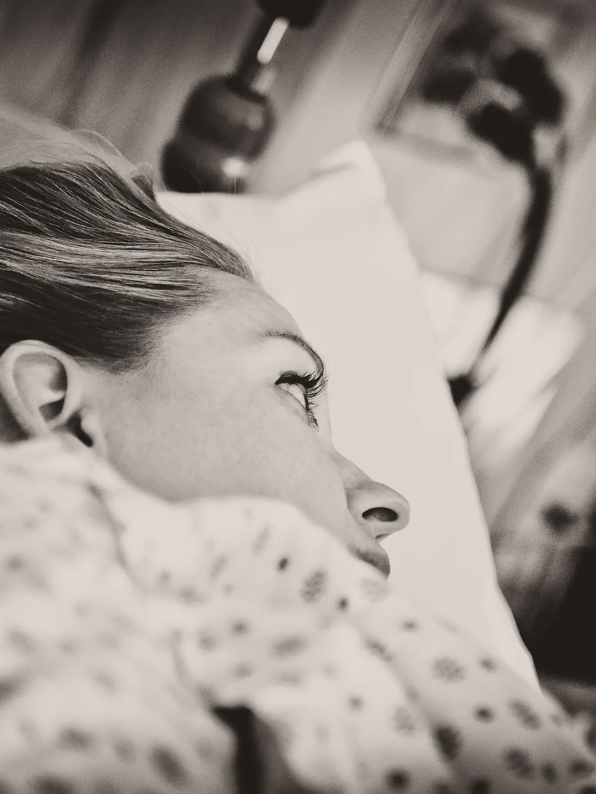 "Horizontal portrait of a young woman, laying in hospital bed in the labour and delivery ward, waiting to give birth to her child. Image is processed in a sepia tone and visible grain has been added. Image is processed from a 16 bit RAW file and profiled in ProPhoto RGB. All my images are professionally retouched.More from this series:"