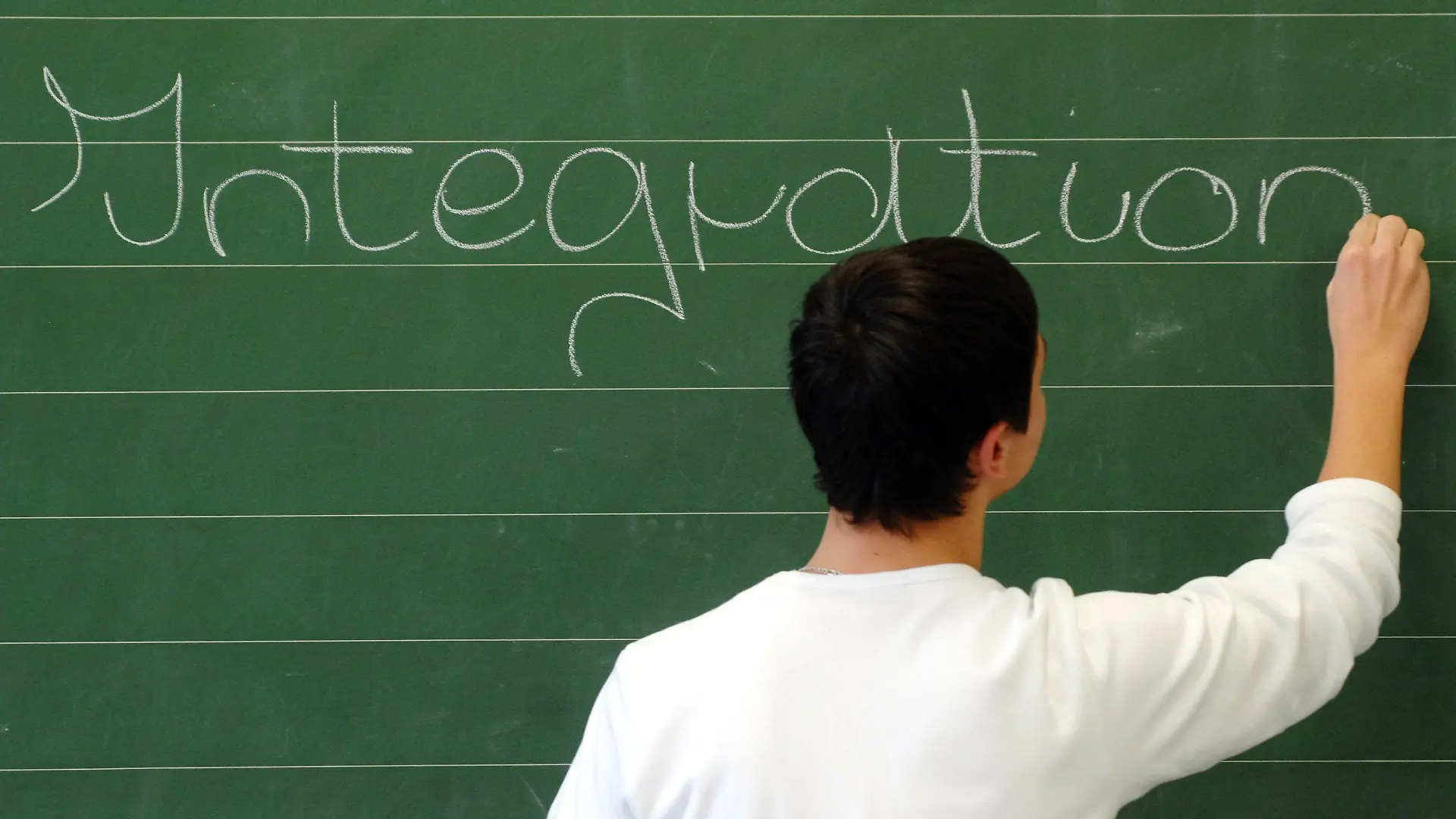 ARCHIV - ILLUSTRATION - Ein Schüler der neunten Klasse an einer Hauptschule in Straubing (Niederbayern) schreibt das Wort «Integration» auf eine Tafel (Archivfoto vom 11.12.2006). Bundeskanzlerin Merkel lädt am Mittwoch (03.11.2010) zum 4. Integrationsgipfel ins Kanzleramt ein. Foto: Armin Weigel dpa +++(c) dpa - Bildfunk+++