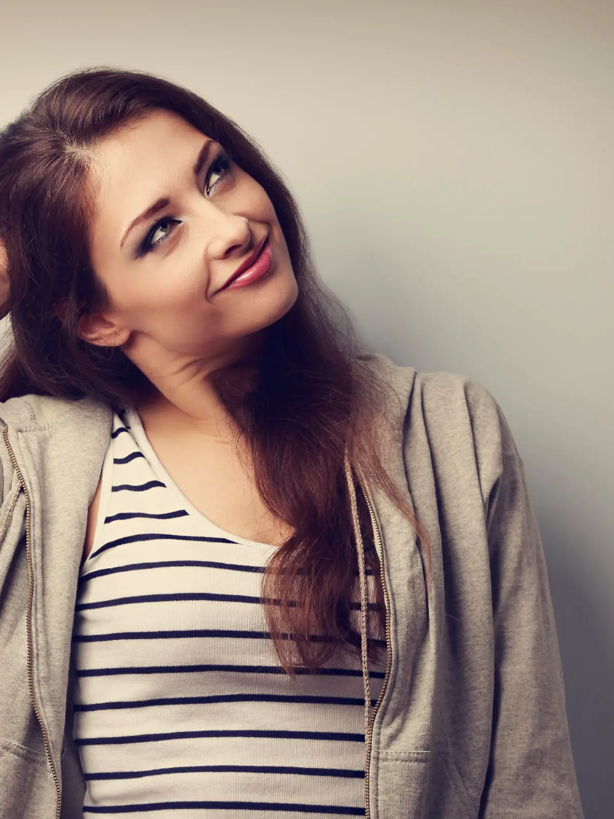 Thoughtful happy beautiful young woman holding the head and looking up. Vintage portrait