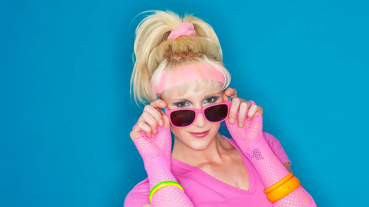 A 1980's styled blonde girl looking at the camera