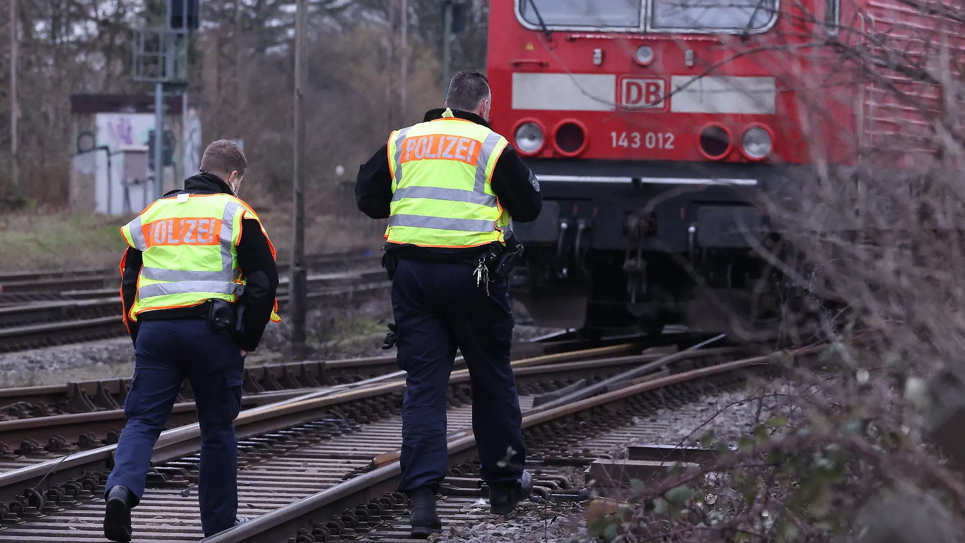 03.02.2023, Nordrhein-Westfalen, Recklinghausen: Zwei Polizisten gehen an einer Lok auf einer Bahnstrecke vorbei. Bei einem tödlichen Unfall in Recklinghausen sind zwei Jungen von einem Güterzug erfasst worden. Der Zehnjährige wurde getötet, der Neunjährige schwer verletzt. Es gebe keine Hinweise auf weitere Verletzte, sagte der Polizeisprecher. Foto: David Young/dpa +++ dpa-Bildfunk +++