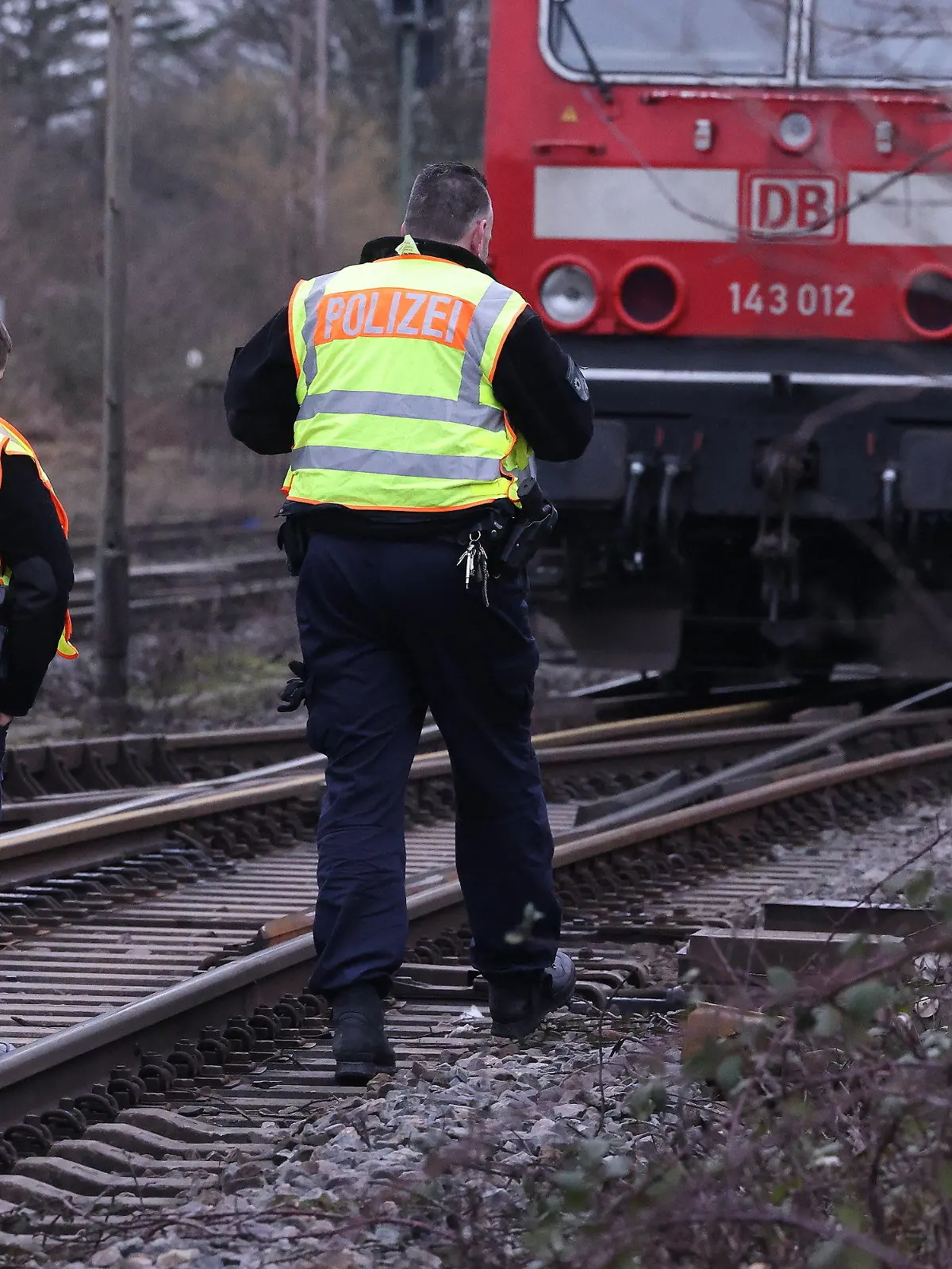 03.02.2023, Nordrhein-Westfalen, Recklinghausen: Zwei Polizisten gehen an einer Lok auf einer Bahnstrecke vorbei. Bei einem tödlichen Unfall in Recklinghausen sind zwei Jungen von einem Güterzug erfasst worden. Der Zehnjährige wurde getötet, der Neunjährige schwer verletzt. Es gebe keine Hinweise auf weitere Verletzte, sagte der Polizeisprecher. Foto: David Young/dpa +++ dpa-Bildfunk +++