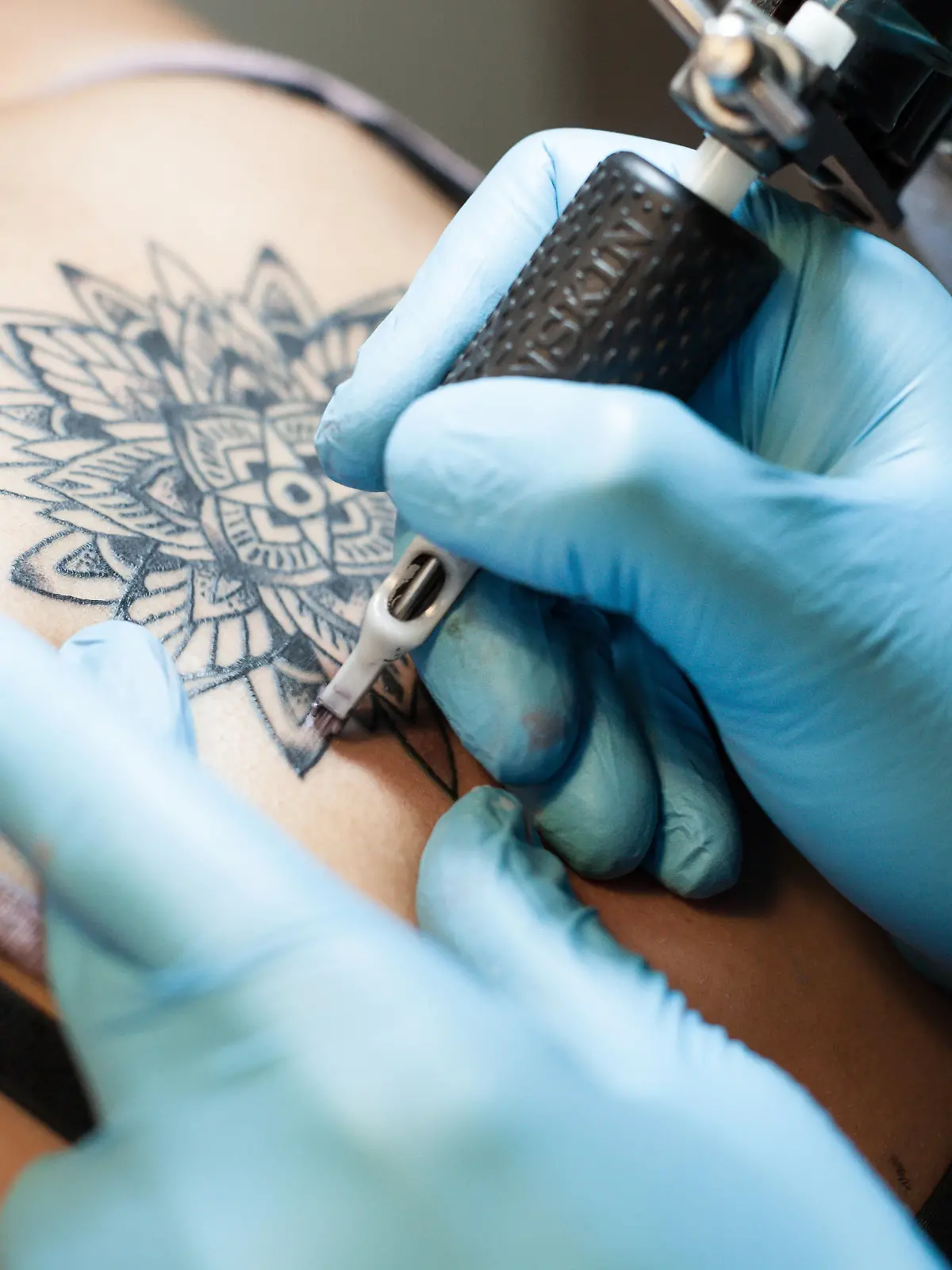 Tätowierer sticht Tattoo.