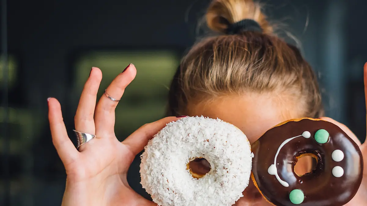 Happy woman holding donuts