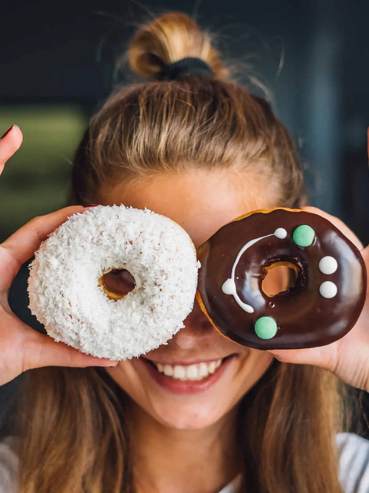 Happy woman holding donuts