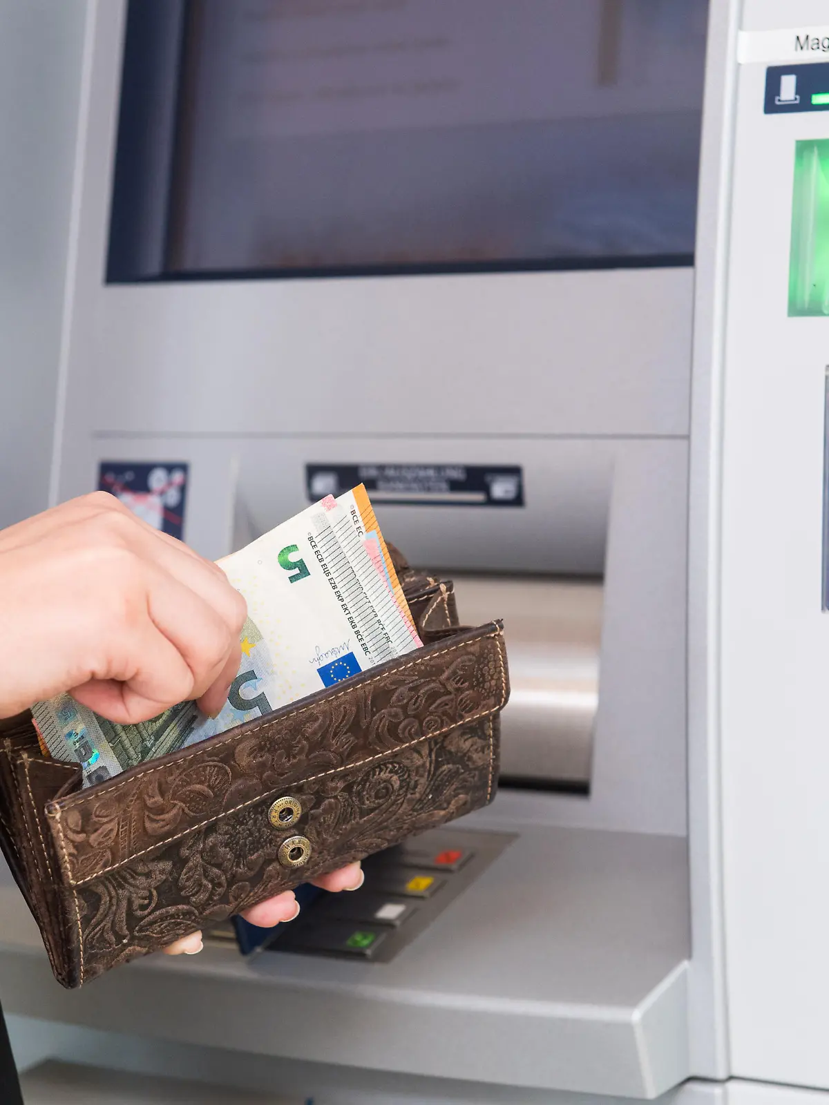 ILLUSTRATION - Eine Frau hebt am 04.04.2019 an einem Geldautomaten in Flensburg Geld ab (gestellte Szene). Foto: Benjamin Nolte