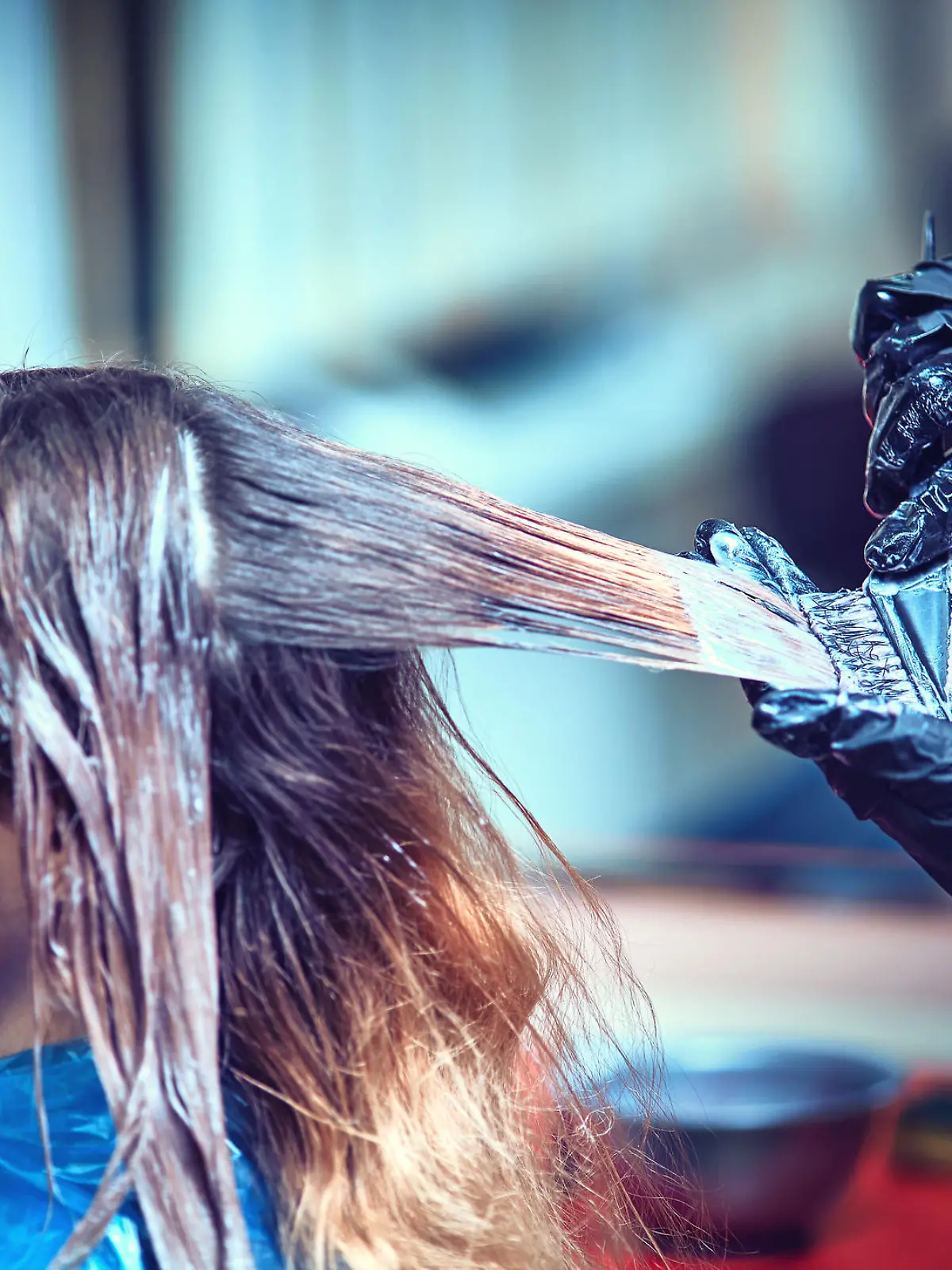 Professional hairdresser dyeing hair of her client