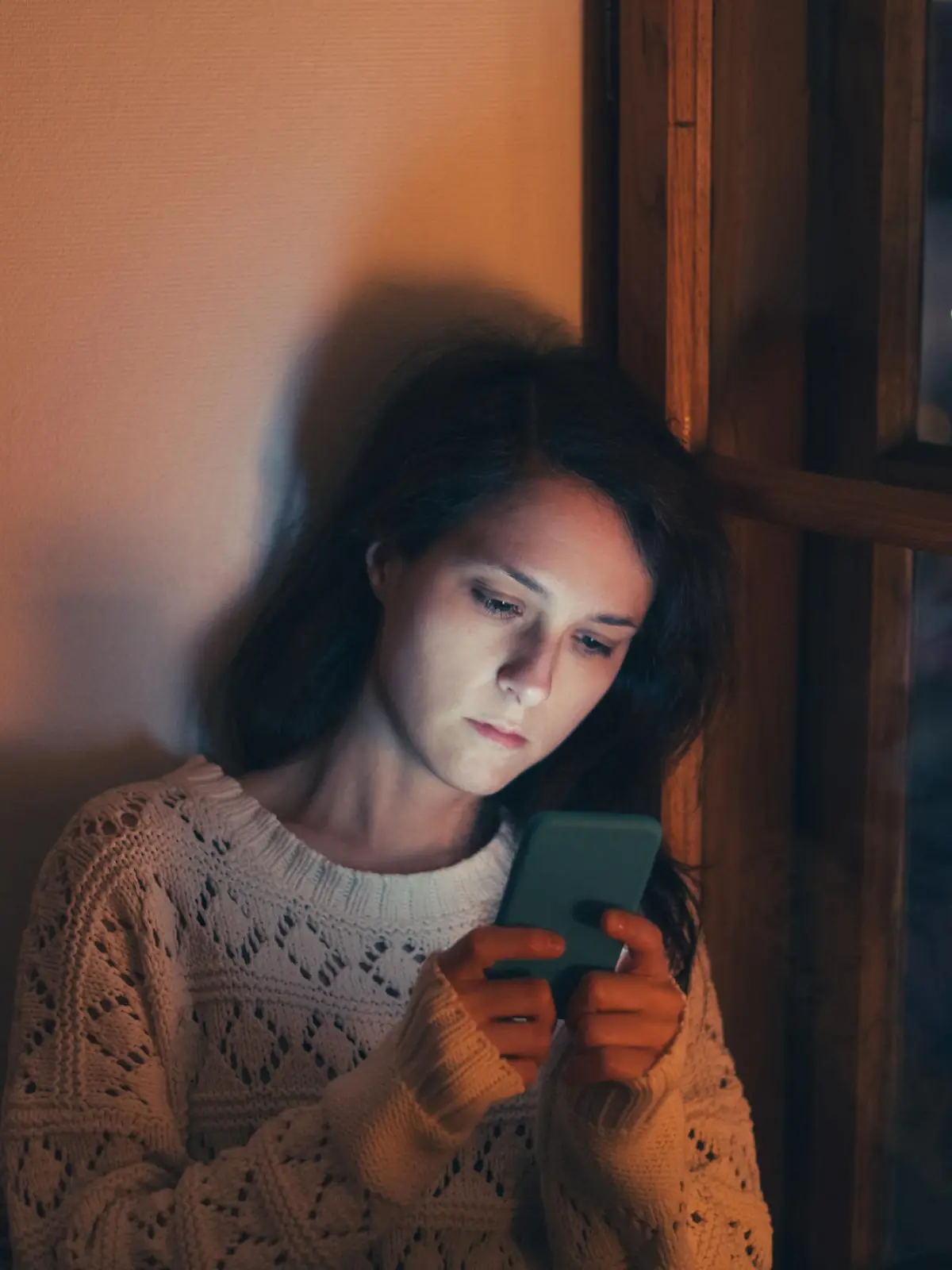 Unhappy woman at home text messaging
