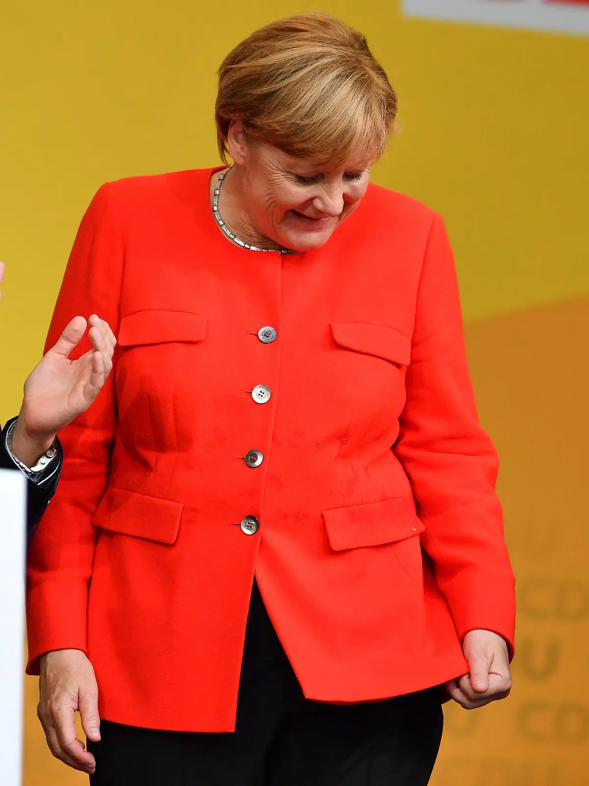 Bundeskanzlerin Angela Merkel schaut am 05.09.2017 in Heidelberg (Baden-Württemberg) auf dem Universitätsplatz bei einer Wahlkampfveranstaltung auf einen Fleck auf ihrer Jacke. Ein Tisch, der vor ihr stand, war von einem Gegenstand aus den Reihen des Publikums getroffen worden, dabei waren Spritzer auf Merkels Jackett gekommen. Links steht der Vorsitzende der CDU Heidelberg, Alexander Föhr. Foto: Uwe Anspach/dpa +++(c) dpa - Bildfunk+++