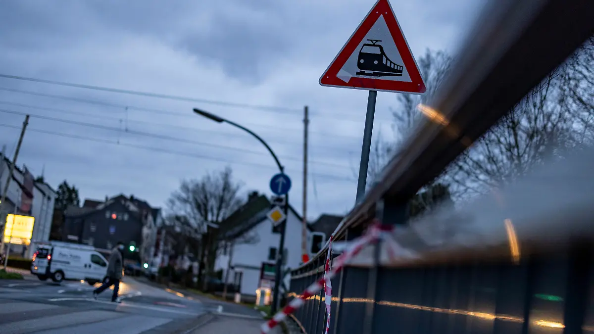 03.02.2023, Nordrhein-Westfalen, Recklinghausen: Flatterband an einem Geländer am Bahnübergang an der Hubertusstraße in Recklinghausen weist auf den tödlichen Unfall an einer Bahnstrecke hin. Bei einem tödlichen Unfall in Recklinghausen sind zwei Jungen von einem Güterzug erfasst worden. Der Zehnjährige wurde getötet, der Neunjährige schwer verletzt. Es gebe keine Hinweise auf weitere Verletzte, sagte der Polizeisprecher. Foto: Christoph Reichwein/dpa +++ dpa-Bildfunk +++