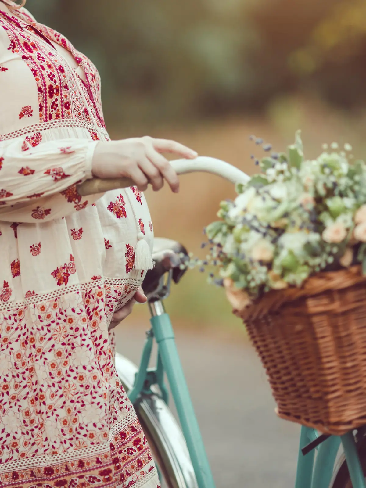 Pregnant belly against nature close-up. Pregnant girl retro French style with bicycle on a forest road. Beautiful pregnancy concept. Blonde happy woman with curly hair on nature background.