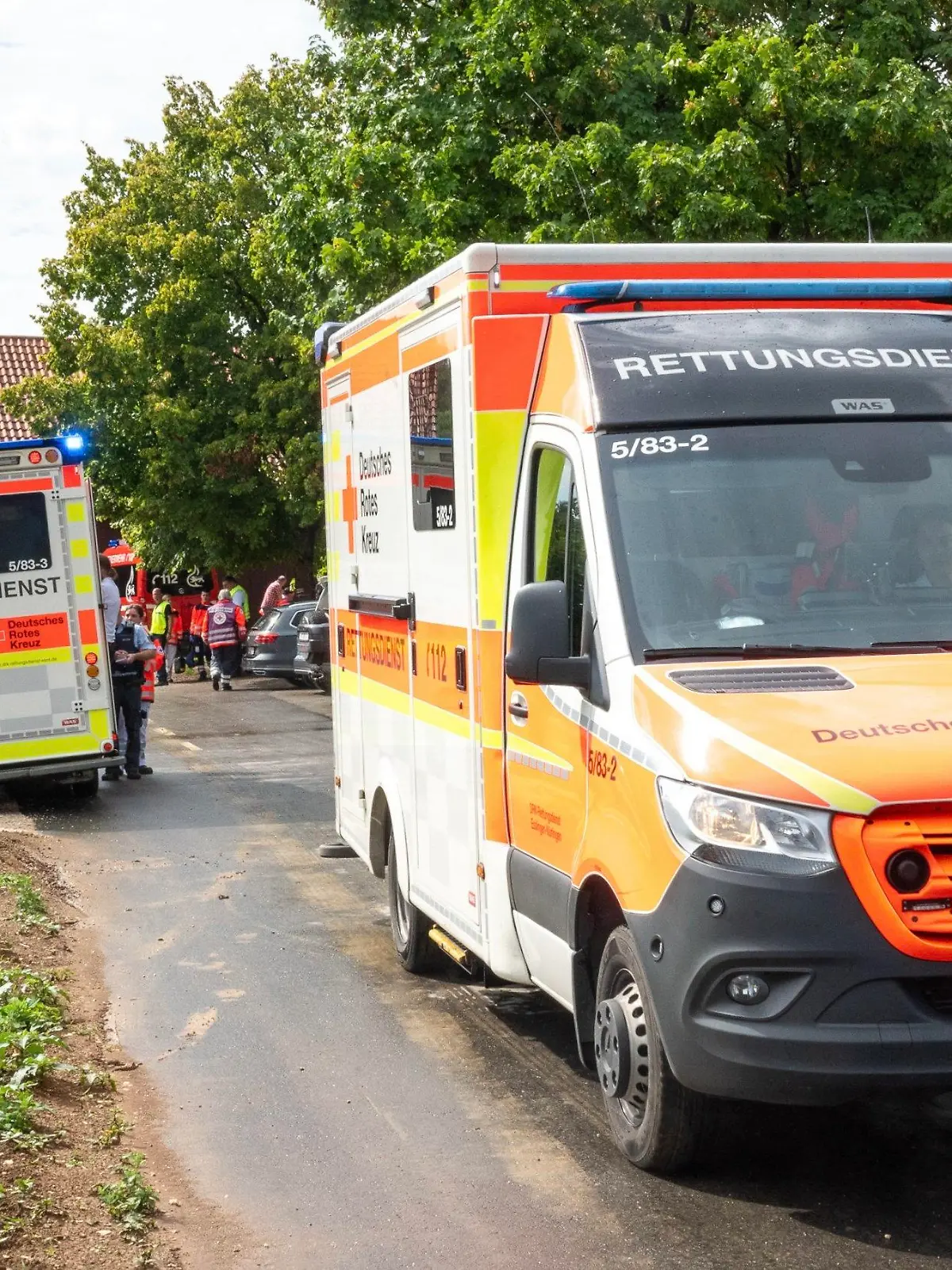 12.08.2023, Baden-Württemberg, Unterensingen: Rettungsdienste stehen nahe der Unglücksstelle. Beim Einschlag eines Blitzes in einen Baum sind sechs Menschen verletzt worden, drei davon lebensgefährlich. Sie hätten sich wohl am Samstag zum Schutz vor einem Gewitter unter den Baum in der Gemeinde Unterensingen südöstlich von Stuttgart gestellt, sagte ein Polizeisprecher. Foto: Sascha Baumann/All4foto.de/dpa +++ dpa-Bildfunk +++