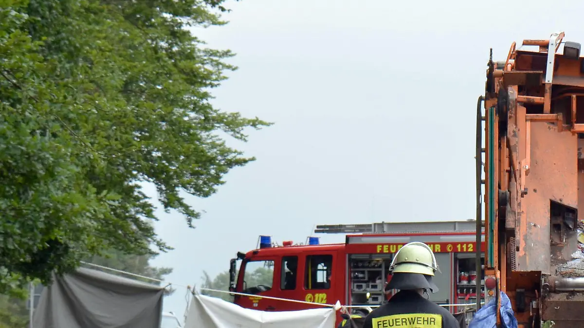 ARCHIV - Feuerwehrkräfte arbeiten am 11.08.2017 auf einer Straße bei Nagold (Baden-Württemberg) an einer Unfallstelle, an der ein Müllwagen auf ein Auto gekippt war. Bei dem Unfall starben fünf Menschen. (zu dpa: «Trauerfeier nach Unfall mit Müllwagen - Großer Andrang erwartet» vom 19.08.2017) Foto: Andreas Rosar/dpa +++(c) dpa - Bildfunk+++