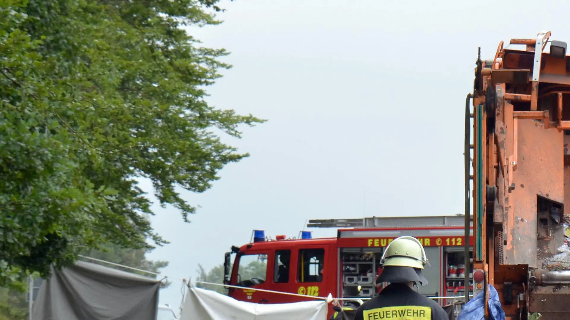 ARCHIV - Feuerwehrkräfte arbeiten am 11.08.2017 auf einer Straße bei Nagold (Baden-Württemberg) an einer Unfallstelle, an der ein Müllwagen auf ein Auto gekippt war. Bei dem Unfall starben fünf Menschen. (zu dpa: «Trauerfeier nach Unfall mit Müllwagen - Großer Andrang erwartet» vom 19.08.2017) Foto: Andreas Rosar/dpa +++(c) dpa - Bildfunk+++