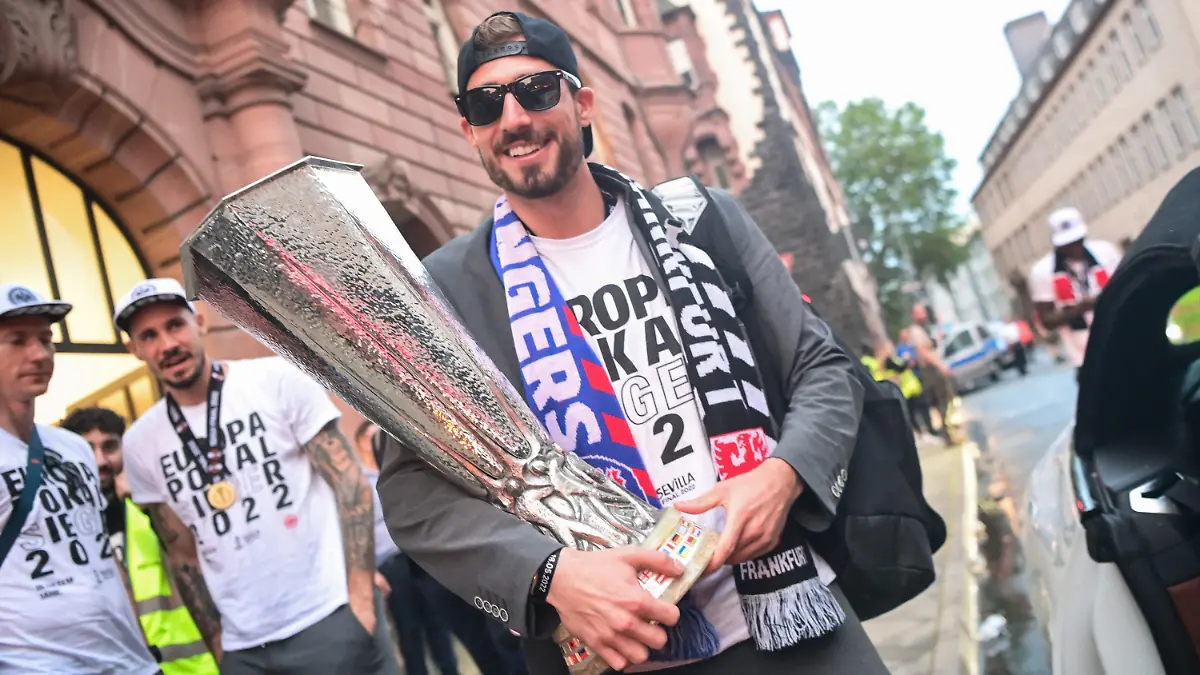 ARCHIV - 19.05.2022, Hessen, Frankfurt/Main: Europa League, nach dem Finalsieg von Eintracht Frankfurt gegen die Glasgow Rangers in Sevilla. Frankfurts Torwart Kevin Trapp kommt mit dem Pokal zur Siegerfeier auf dem Römerberg. Der Nationalkeeper hat seinen Vertrag bei den Hessen um mindestens zwei weitere Jahre verlängert. (zu dpa: ««Sexy Torwart» bleibt in Frankfurt: Trapp unterschreibt bis 2026») Foto: Sebastian Gollnow/dpa-Pool/dpa +++ dpa-Bildfunk +++