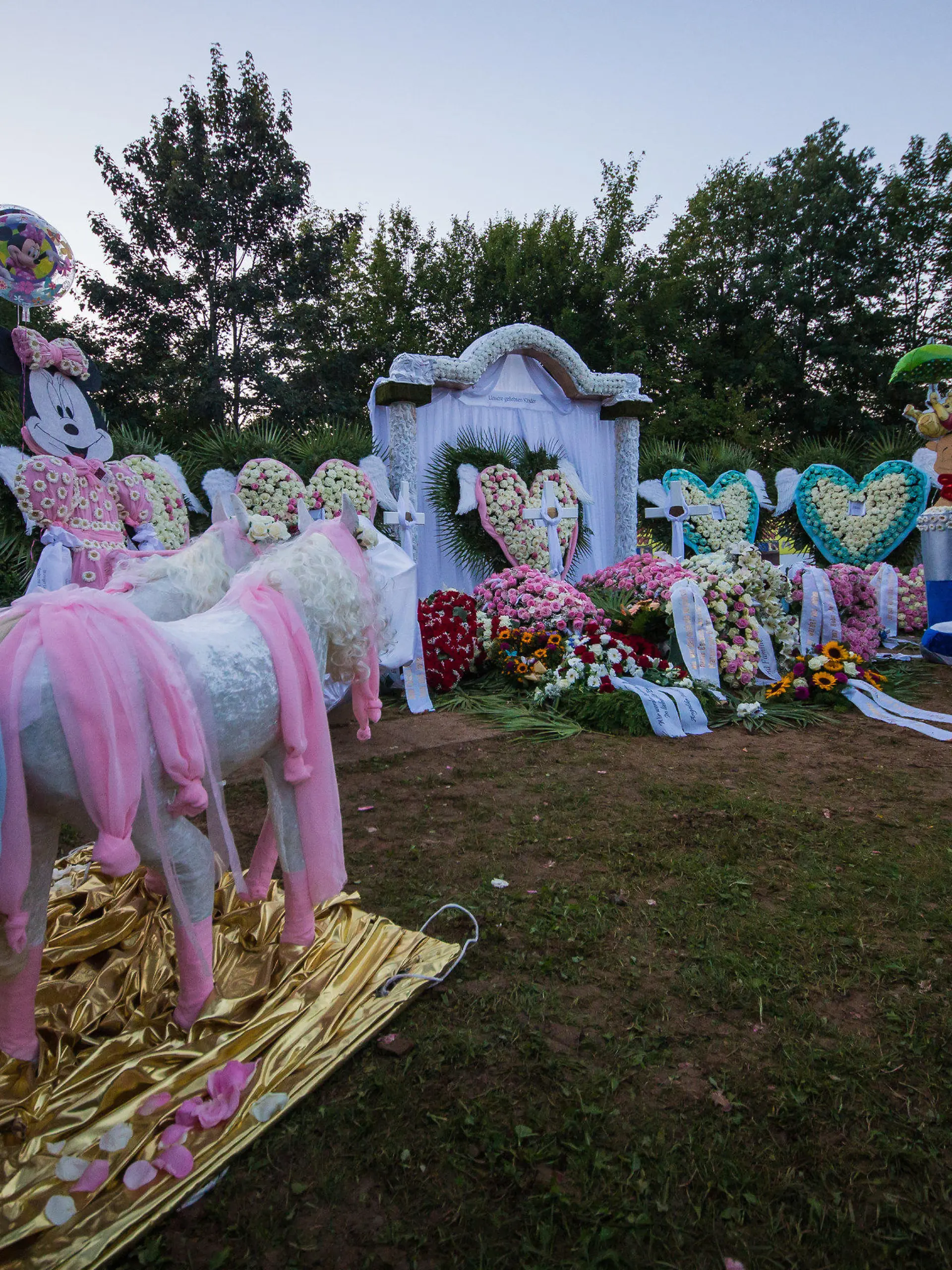 Eine kleine goldene Prinzessinnenkutsche verziert mit Blumen ist am 19.08.2017 nach der Trauerfeier und Beerdigung für eine fünfköpfige Familie, die am 11. August auf der Landstraße 361 zwischen Nagold und Mötzingen (Baden-Württemberg) von einem umgestürzten Müllwagen getötet wurde, am Grab auf dem Friedhof in Mötzingen (Baden-Württemberg) zu sehen. (zu dpa "Trauerfeier mit Applaus - Opfer des Müllwagen-Unglücks beerdigt" am 19.08.2017) Foto: Christoph Schmidt/dpa +++(c) dpa - Bildfunk+++