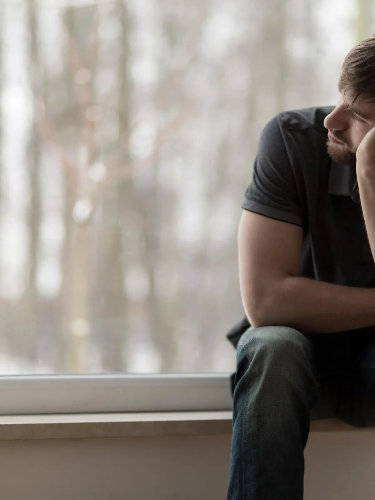 Young miserable depressed man sitting and thinking