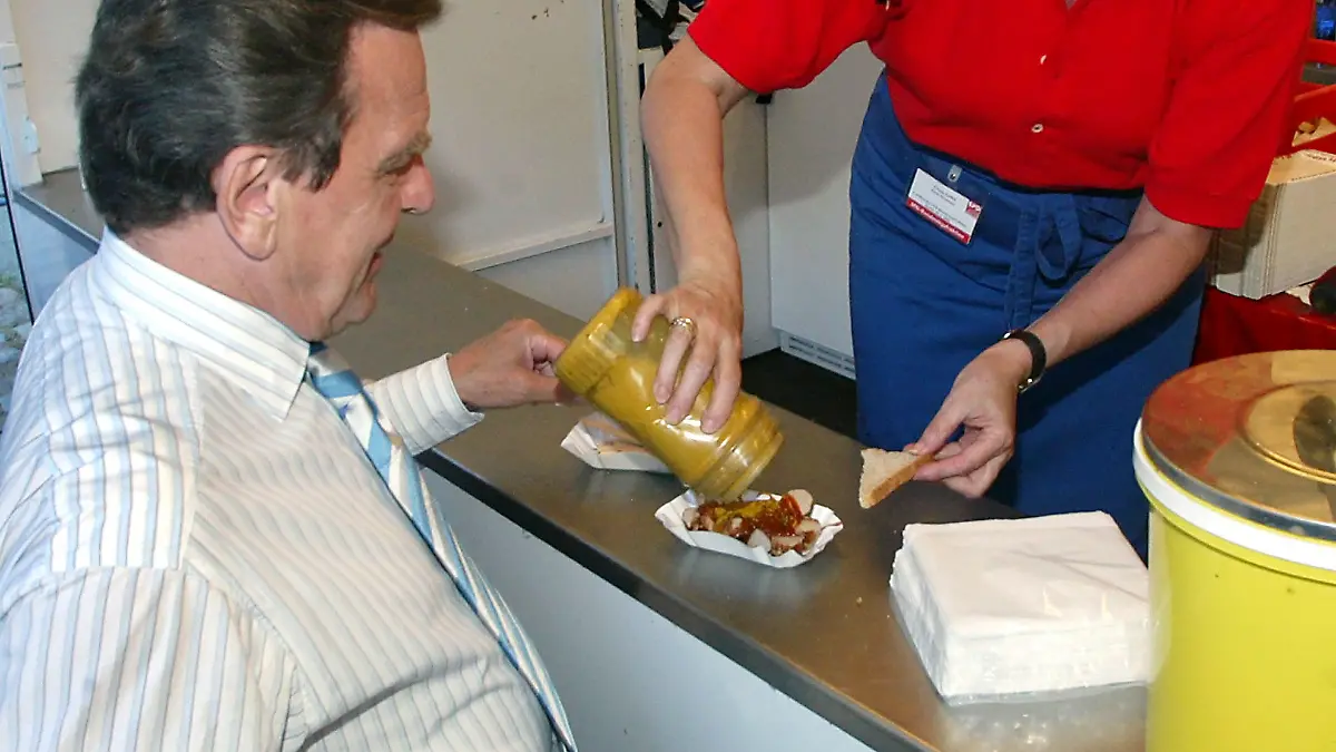 Bundeskanzler Gerhard Schröder läßt sich am Dienstag (28.06.2005) beim Hoffest der SPD in Berlin an einem Currywurststand eine Berliner Spezialität zubereiten.