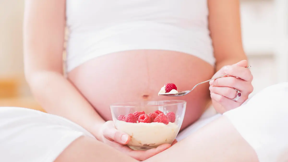 Portrait of pregnant woman eating breakfast, Aufnahme der schwangeren Frau, die Fruehstueck isst Keine Weitergabe an Drittverwerter.