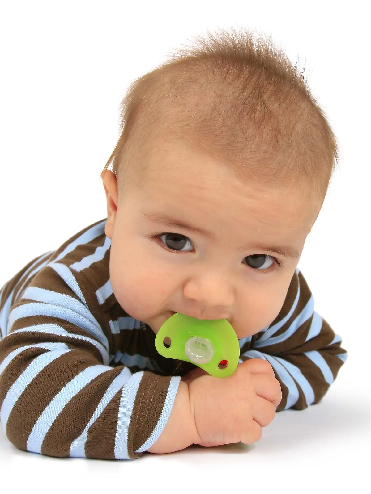 Baby mit Schnuller auf dem Bauch liegend
