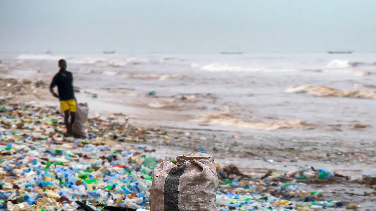 ARCHIV - Ein Mann sammelt am 13.06.2017 bei Accra (Ghana) verwertbares Material am verschmutzten Korle Gono Strand. Die Vermüllung der Meere steht im Mittelpunkt einer am 30.05.2017 beginnenden dreitägigen Konferenz mit Vertretern der G20-Staaten in Bremen. (zu dpa "Konferenz der G20-Staaten berät Maßnahmen gegen Vermüllung der Meere" vom 29.05.2017) Foto: Christian Thompson/EPA/dpa +++(c) dpa - Bildfunk+++